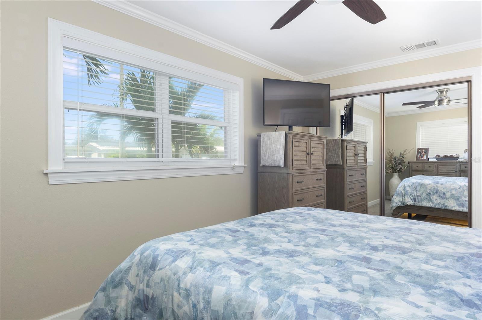 The primary bedroom closet with mirrored doors.