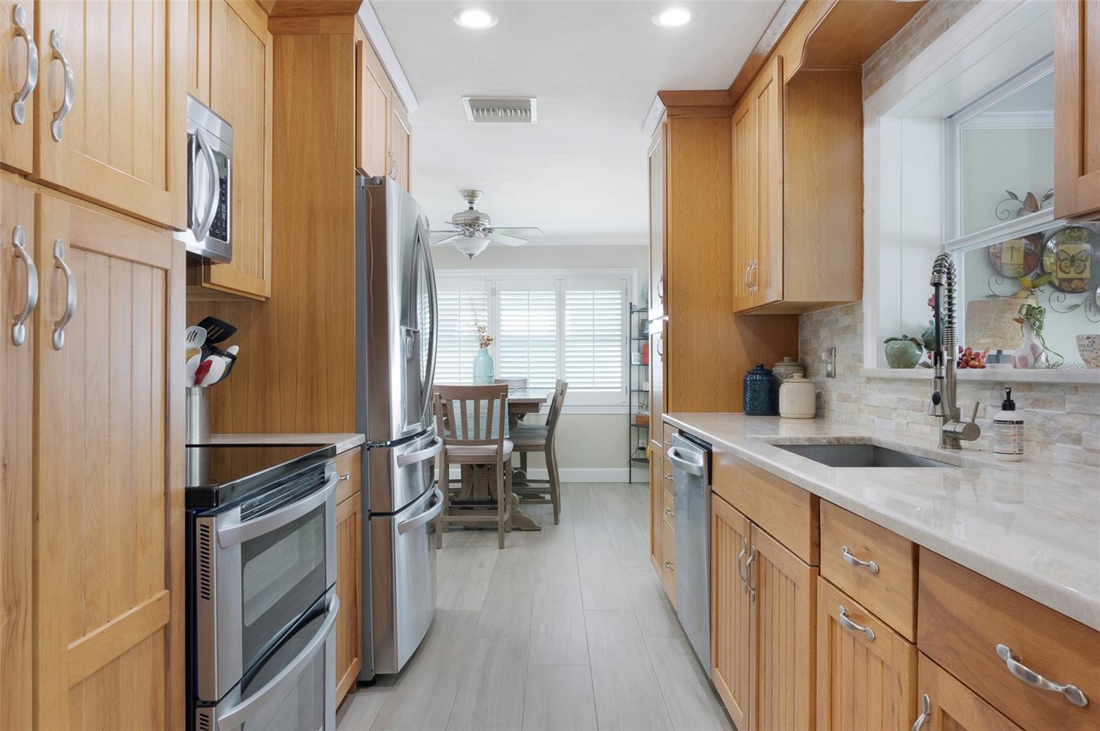 Enter into the galley kitchen where you will notice, not one but 2 pantry cabinets, (with roll out shelves), a farm sink, and beautiful stainless steel appliances.