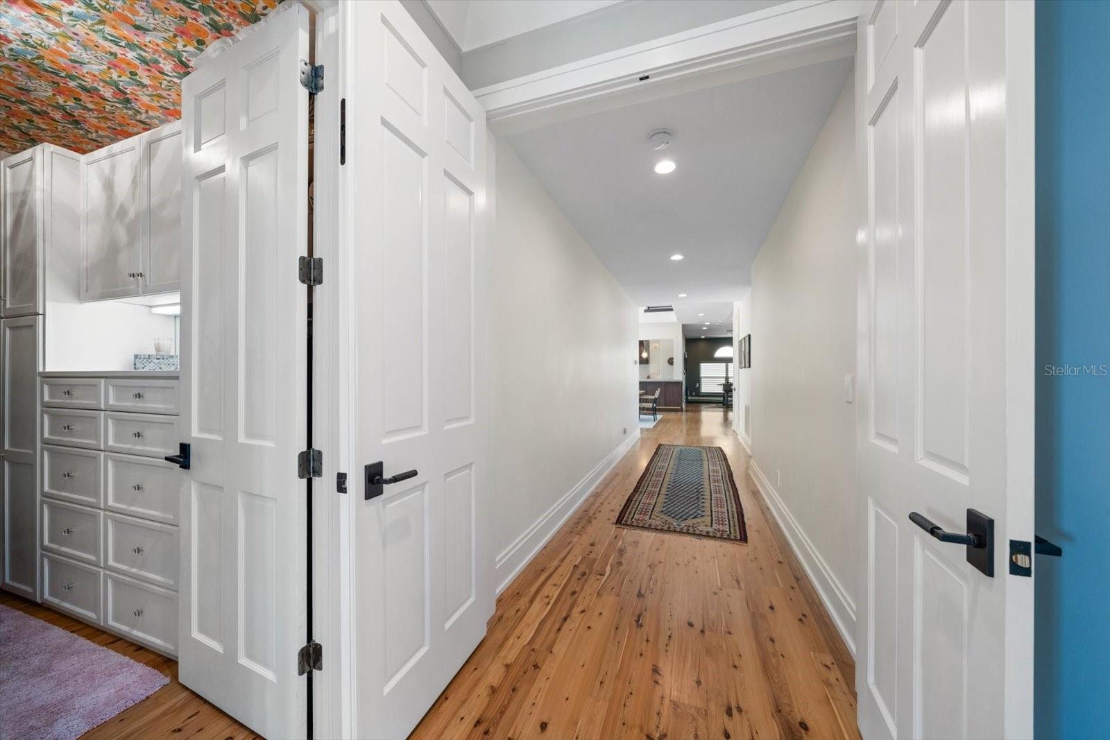 Hallway that leads to the main-floor master suite with spacious his and hers closets