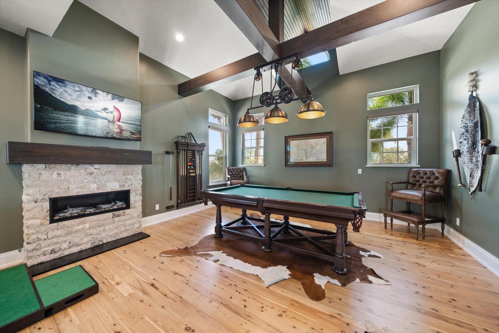Game room with gas fireplace and high ceilings