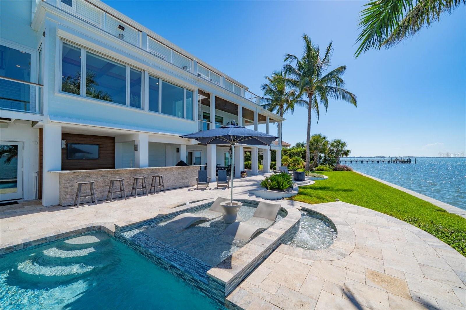 Travertine deck with saltwater pool and sunshelf