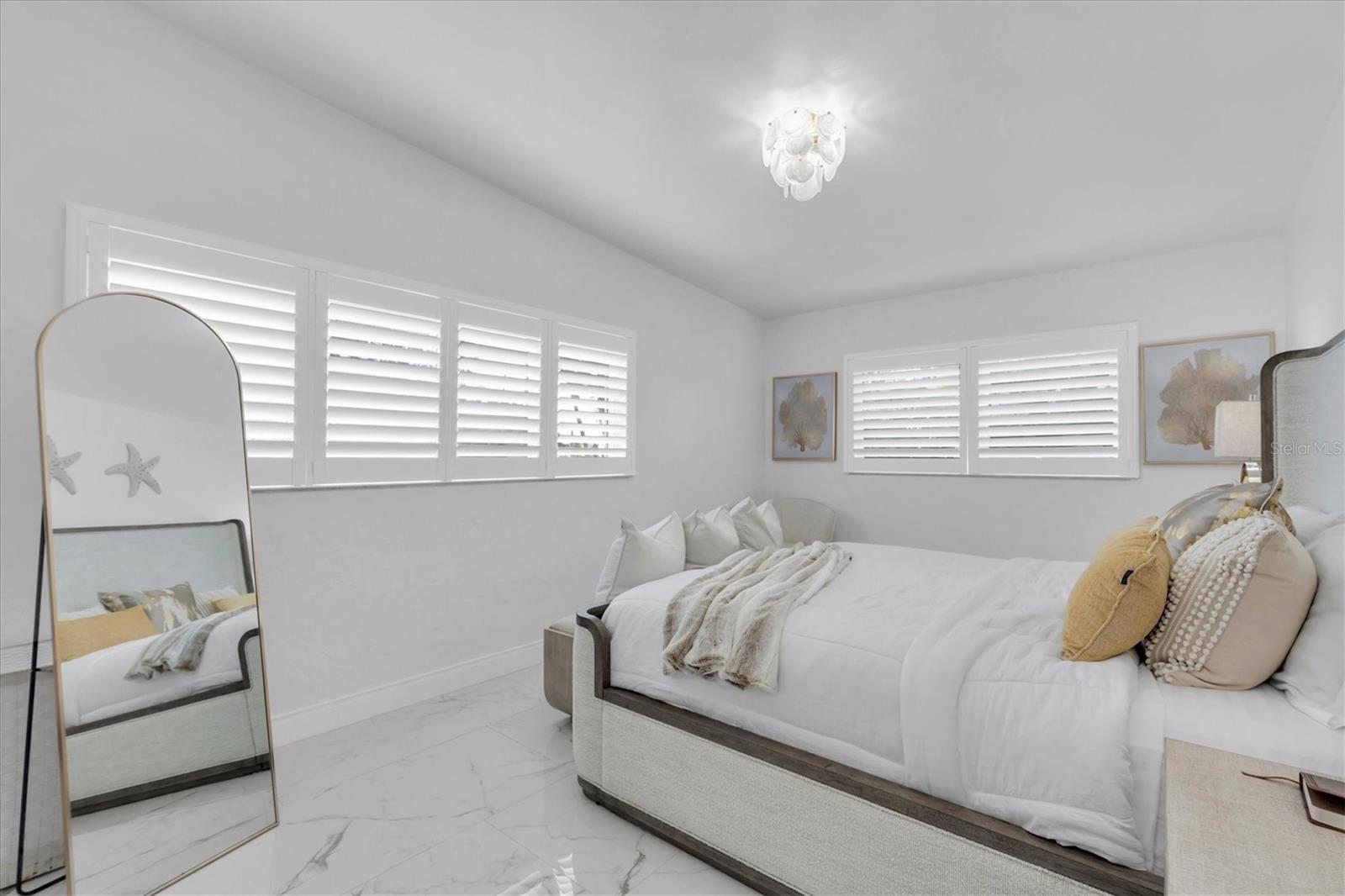 The primary bedroom is spacious with plantation shutters.