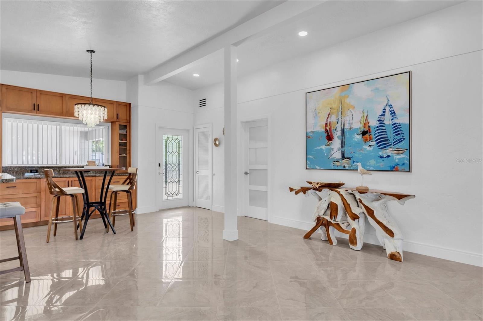 Light-filled foyer with etched-glass entry door opens to breathtaking blue-water views and an inviting open-concept layout designed for effortless coastal living.