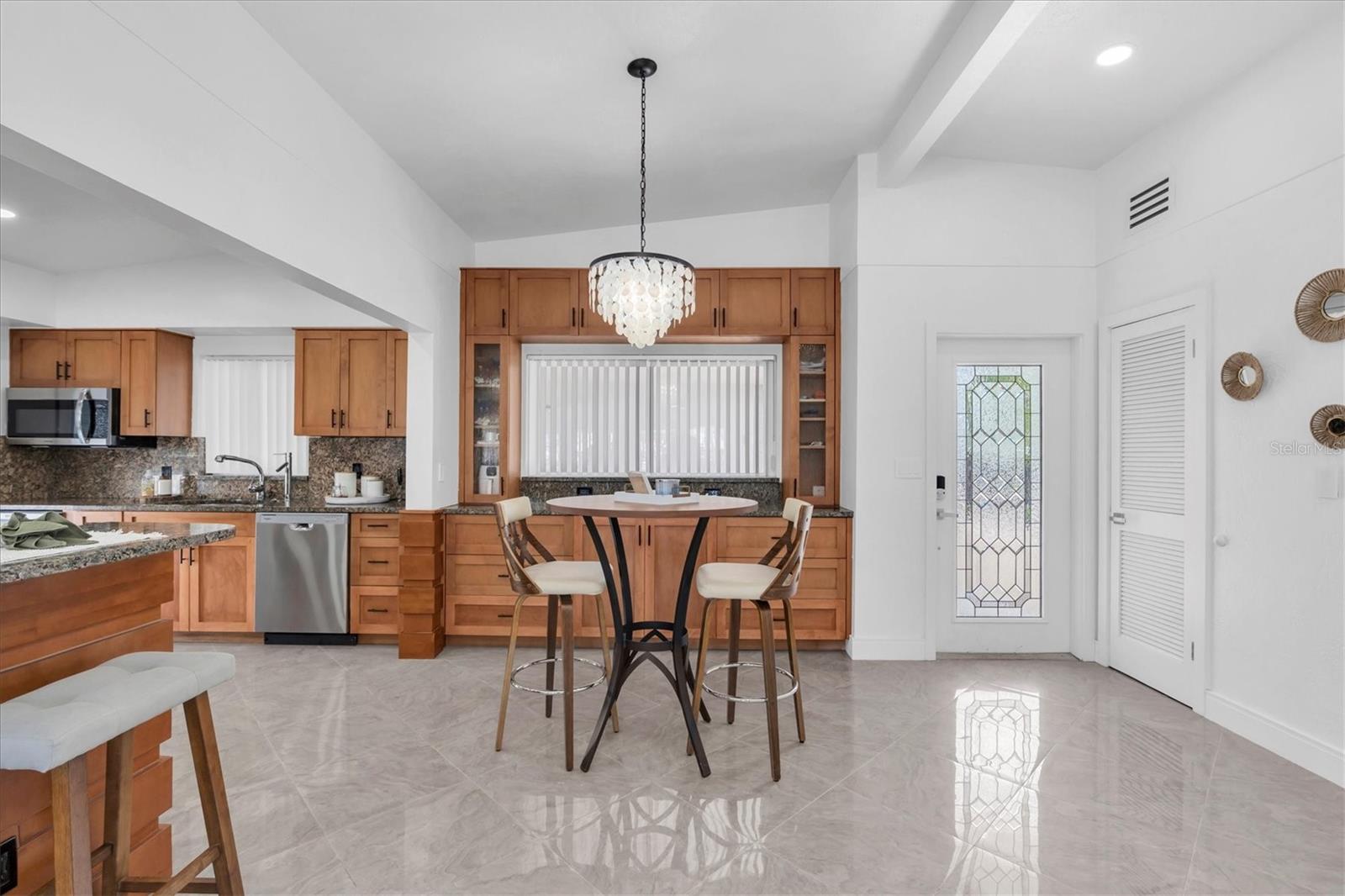 In addition to the dining room and large snack bar, the kitchen comfortably accommodates a table. Porcelain floors and the home’s clean, elegant design create a truly dreamy space.