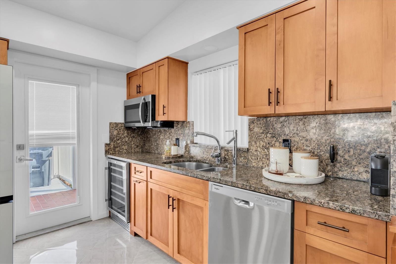 The kitchen features abundant counter space for gourmet cooking, all while enjoying stunning views of azure waters, blue skies, and coastal landscaping.
