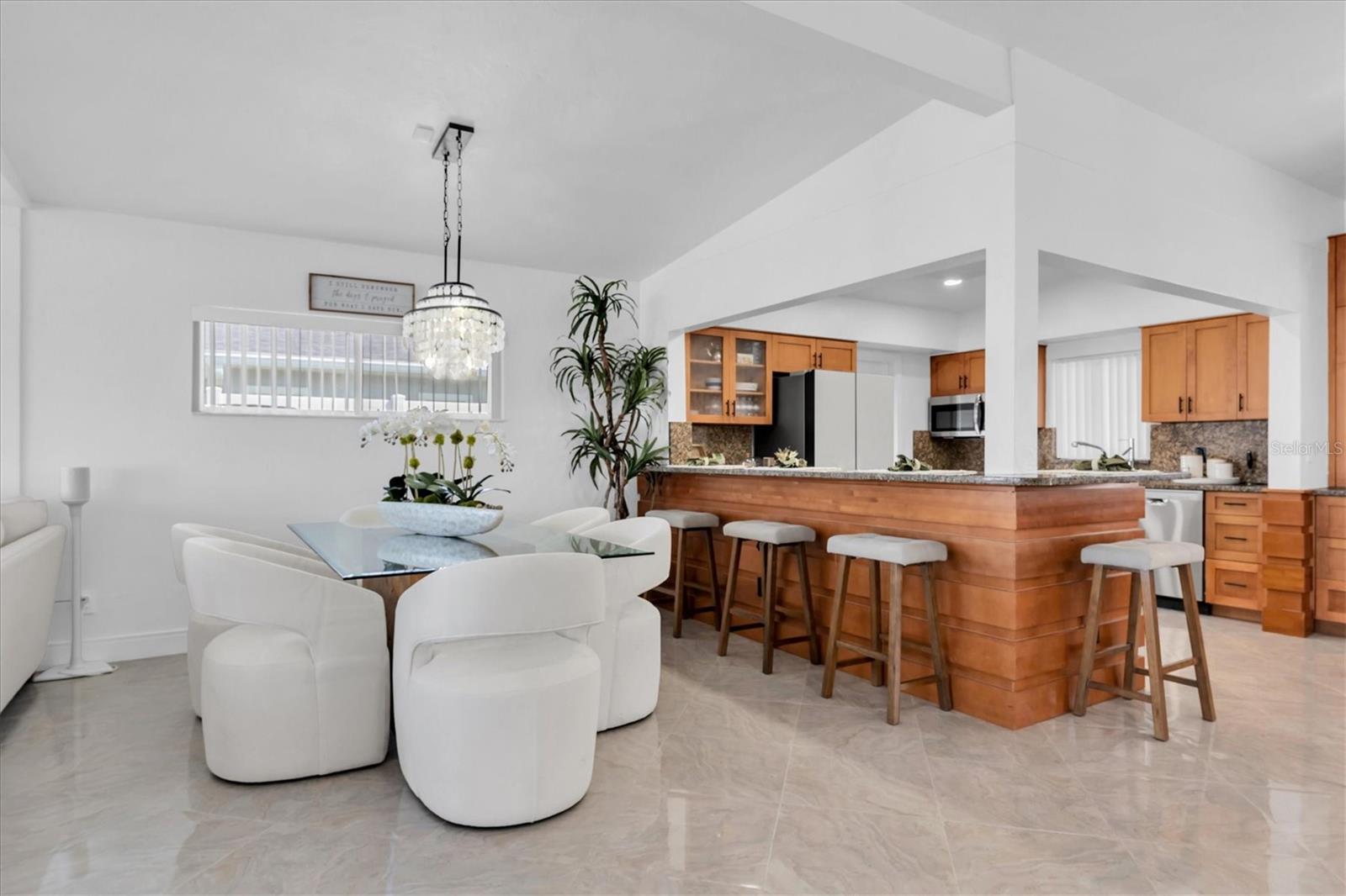 The dining room with high ceilings, open floor plan, and stunning water views, flowing to the kitchen is perfect for entertaining!