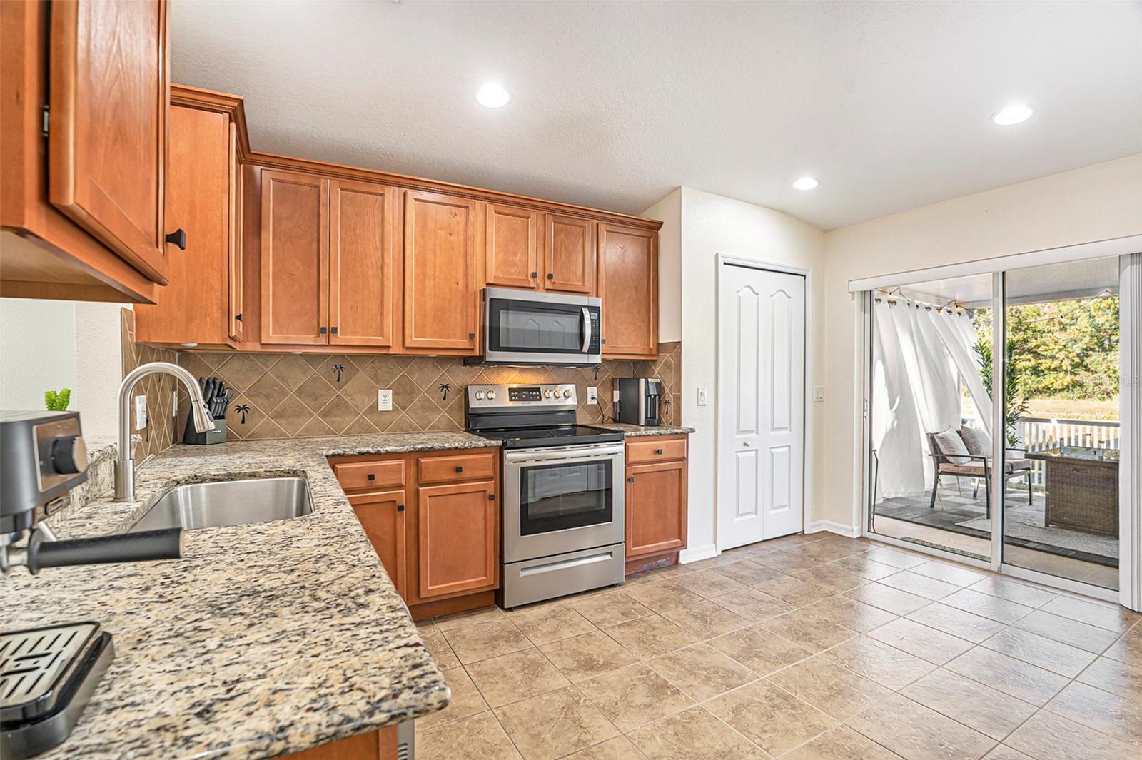 Large kitchen featuring granite counters & custom backsplash