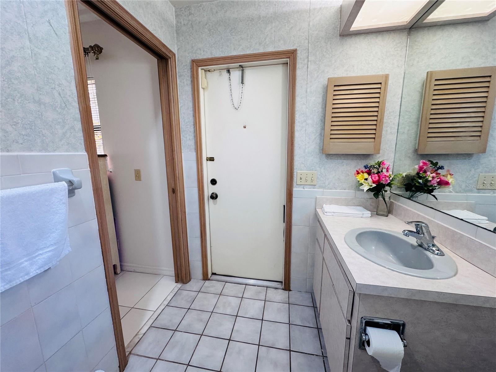 This bath has access to the backyard pool area.