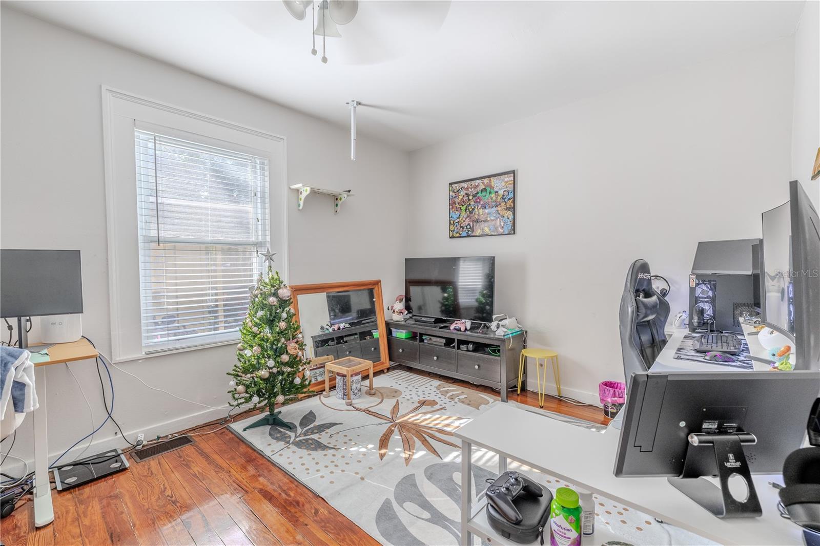 This spacious first-floor bedroom offers flexibility for use as a guest room, office, or family bedroom. Large windows provide excellent natural light, while the beautifully maintained wood floors add warmth and character. The room includes a built-in closet for convenient storage and features direct access to a full bathroom, enhancing privacy and functionality. This main-level bedroom is a valuable addition to the home’s versatile layout.