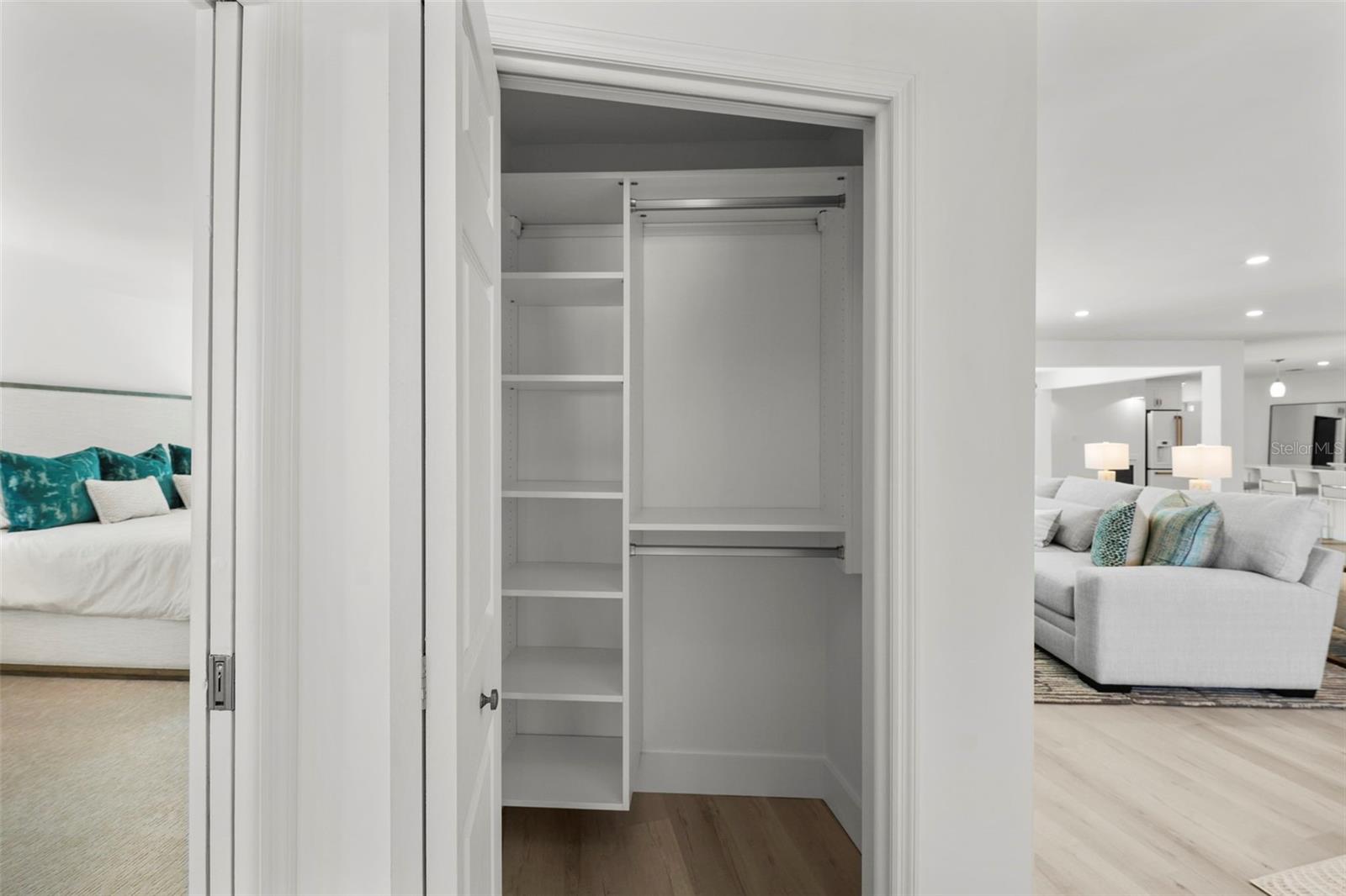 Conveniently located additional storage with tailored shelving, just outside the door of the primary suite.