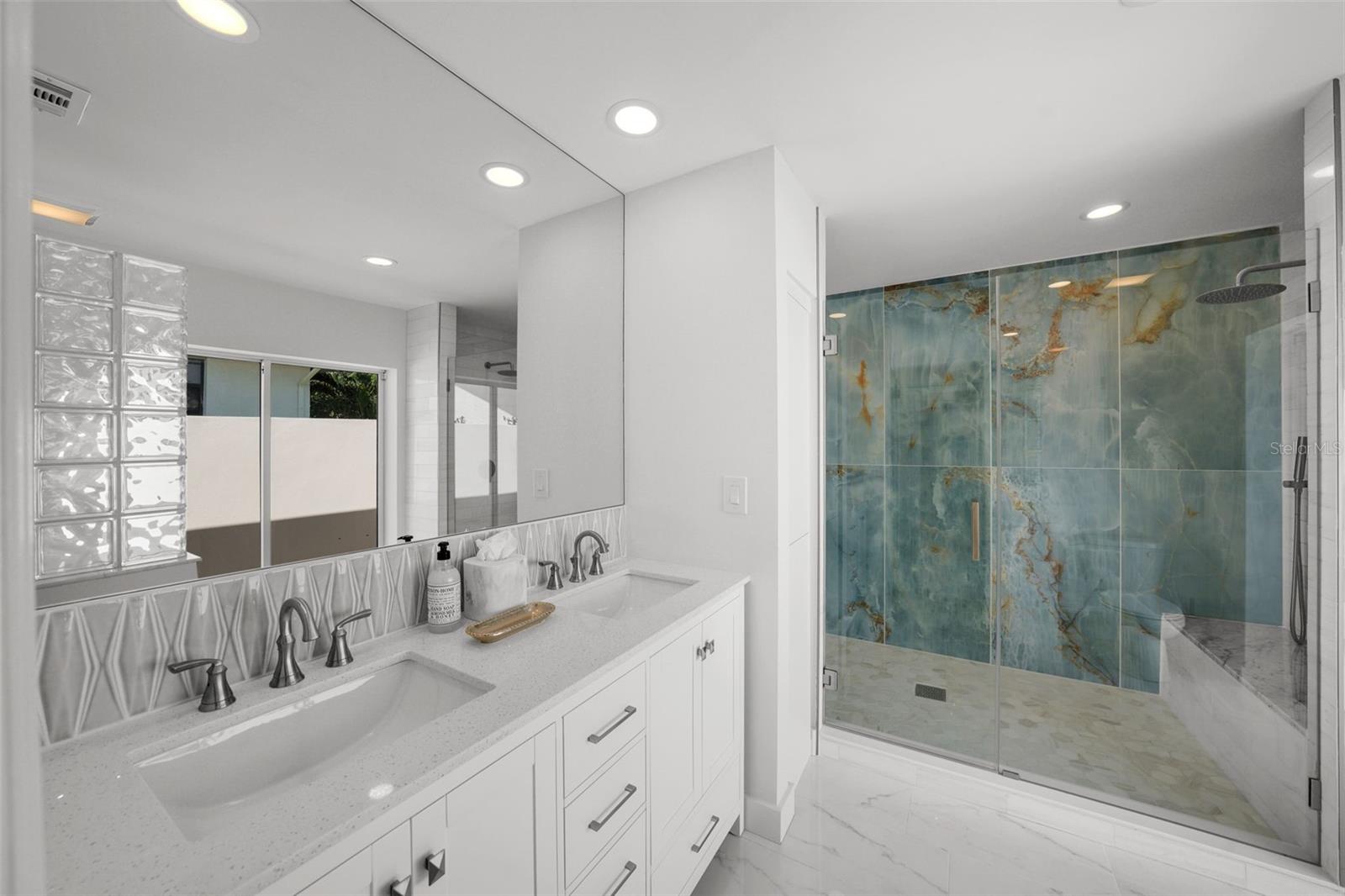 A spa-inspired shower featuring dual benches and dual luxury shower heads.