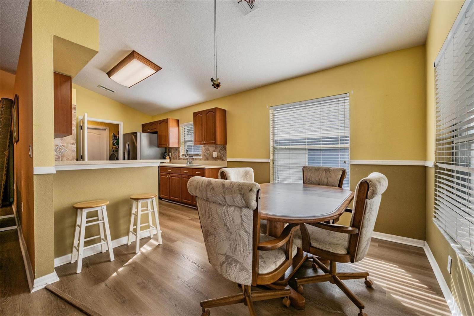 Eat in kitchen with bar and 2 windows and sliders to the enclosed patio.  Vaulted ceilings.