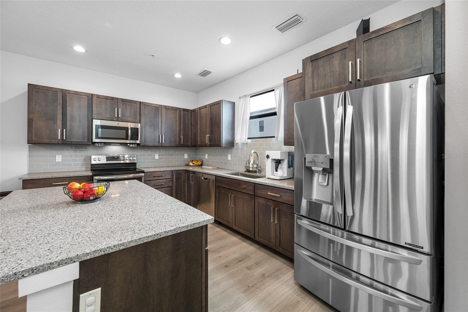 Gourmet kitchen with quartz countertops, Open to the dinning and living room. 10 ft ceilings and oversized windows let in lots of natural light. Second Floor