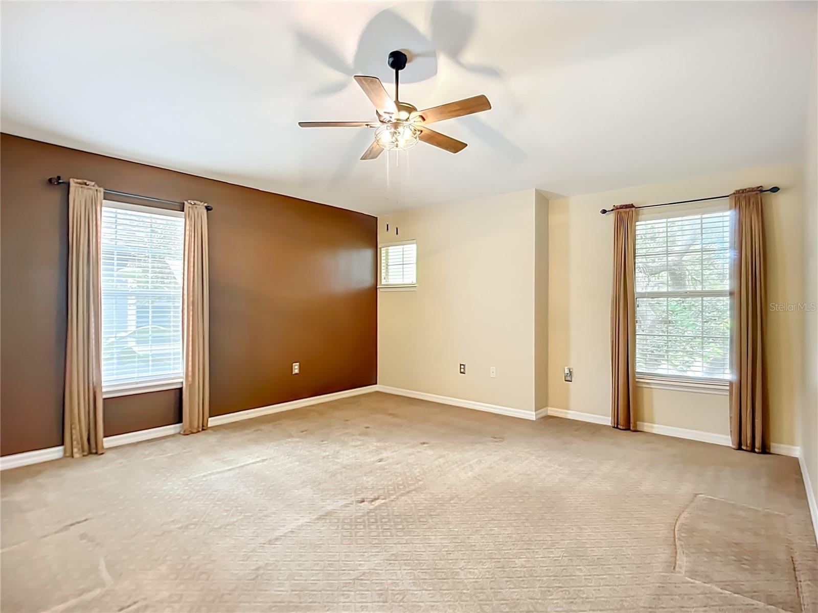 Spacious primary bedroom with high ceiling.