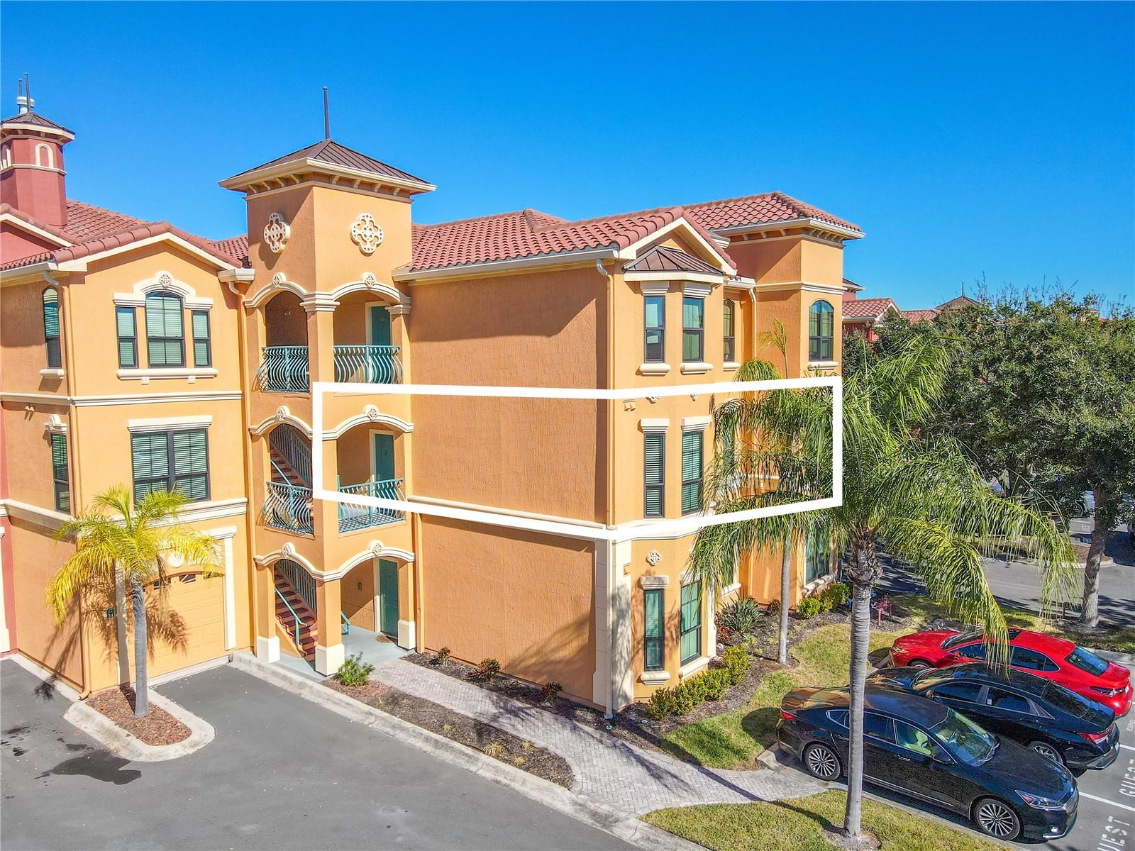 This second floor condo features open, light-filled living area features crown molding, laminate flooring, a modern ceiling fan, and a cozy gas fireplace, flowing seamlessly into the dining space for effortless everyday living and entertaining.