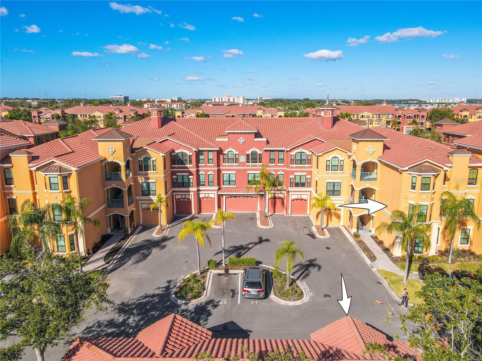 A vibrant Mediterranean-style enclave unfolds beneath blue skies, where palm-lined courtyards and elegant façades set the stage for resort-inspired living in this second floor condo with deeded garage as shown at The Grand Bellagio.