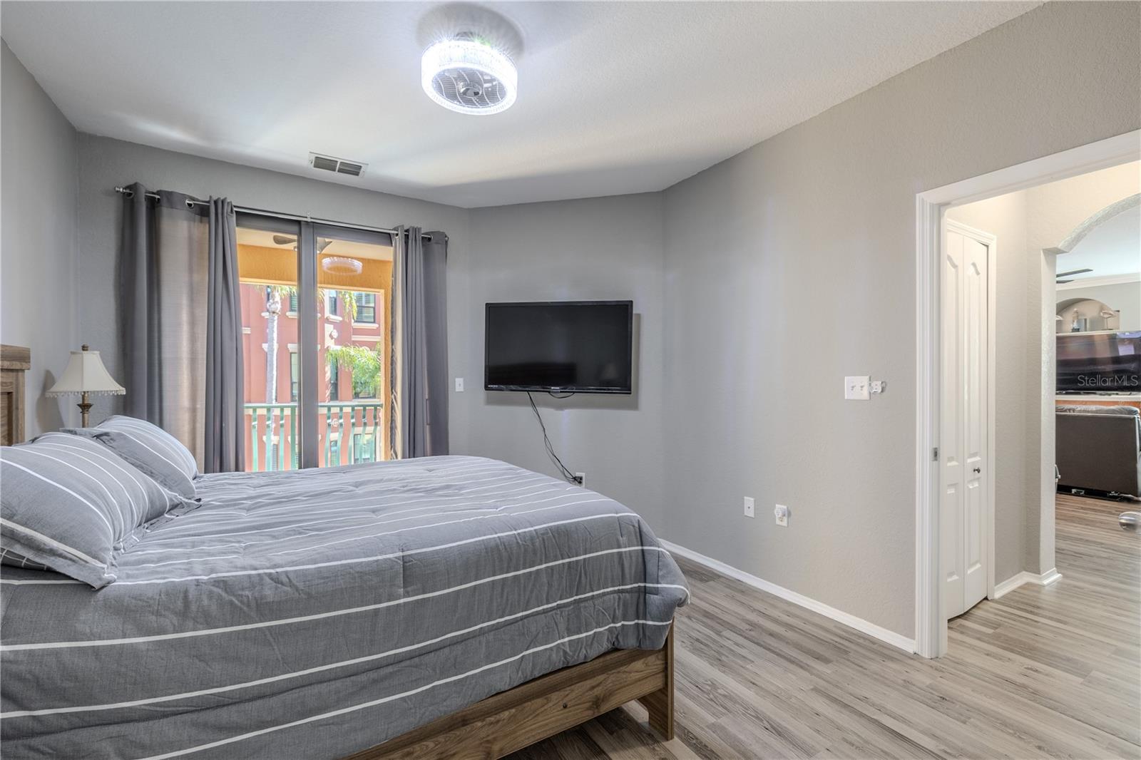 A en-suite bathroom view of the primary bedroom retreat featuring sliding glass doors to the private balcony, soft neutral tones, modern lighting, and easy access to the main living area, creating a bright and comfortable space to unwind.