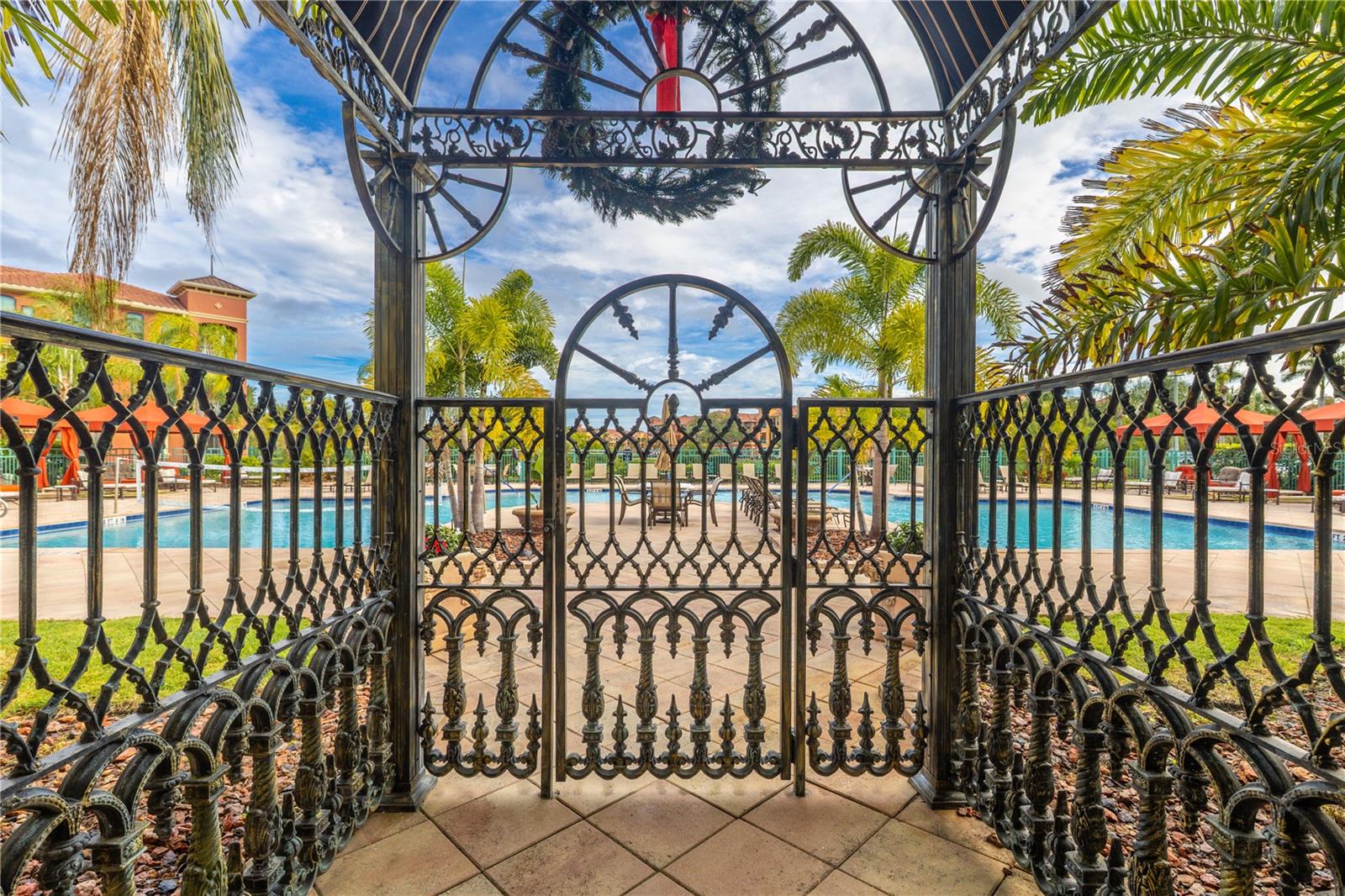 Gated entrance to the resort-style heated clubhouse pool and spa with a spacious sundeck, lounge seating, and private rentable cabanas—perfect for relaxing, entertaining, and soaking up the Florida sunshine.