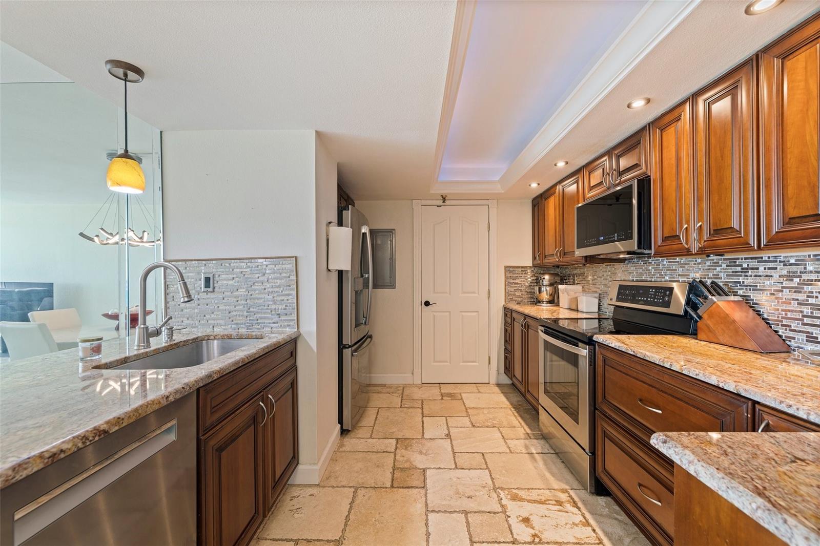 KITCHEN  AND THE ENTRANCE TO THE ADJACENT LAUNDRY ROOM WITH A FULL SIZE WASHER AND DRYER