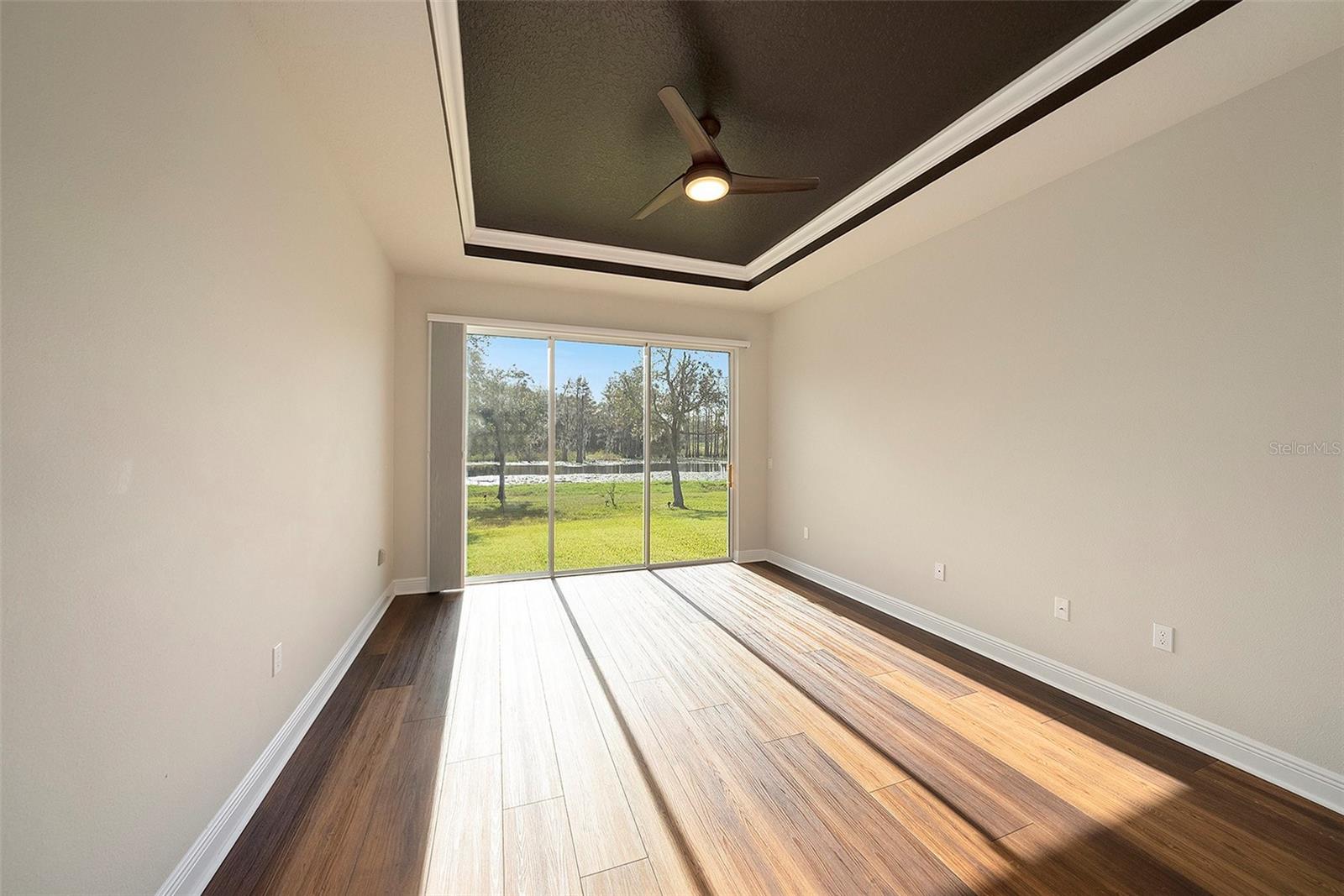 Primary bedroom with large sliders overlooking pond