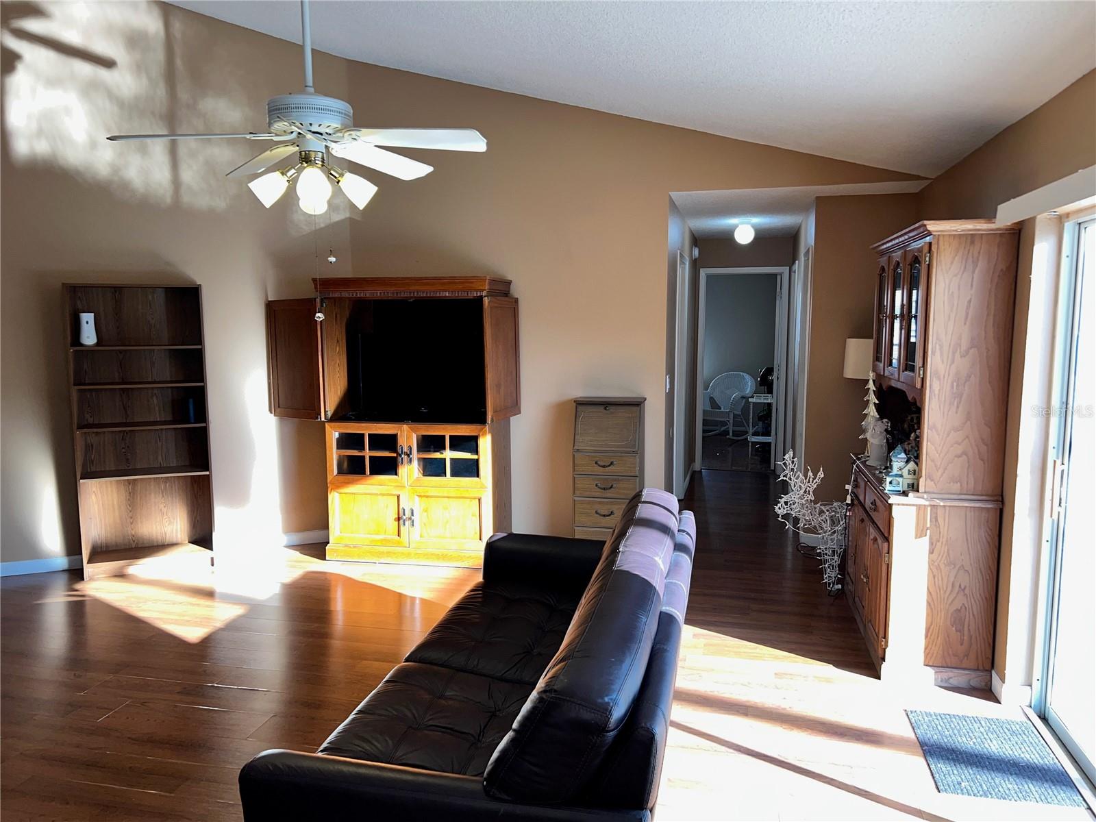 Family room and hallway leading to second and third bedrooms, hall bath, and laundry room.