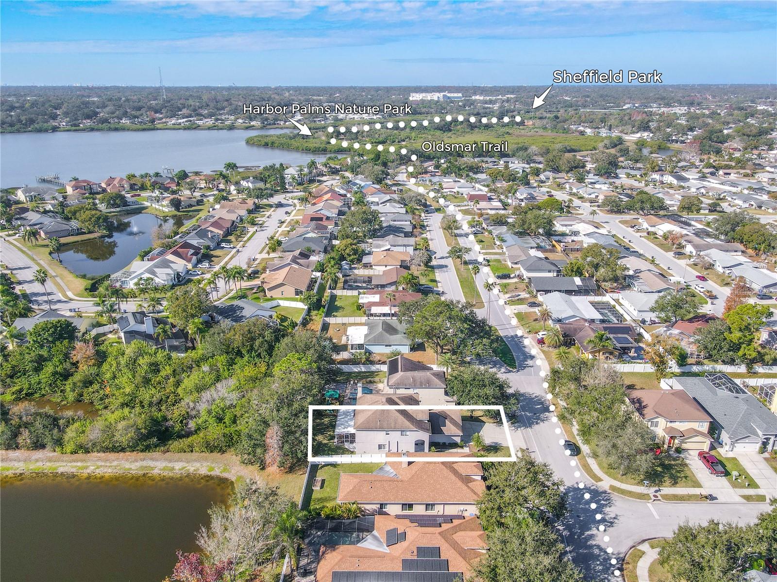 Aerial view highlights the home’s prime Oldsmar location with easy access to the Oldsmar Trail and nearby favorites like Harbor Palms Nature Park and Sheffield Park, plus close proximity to waterfront scenery.