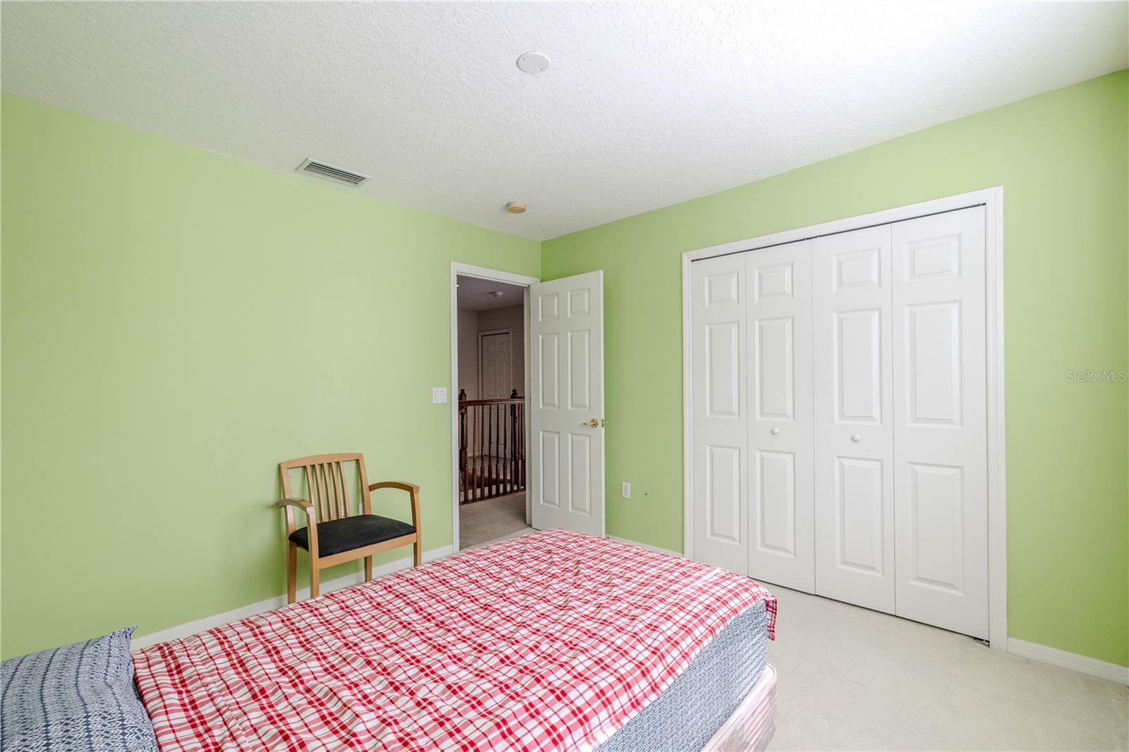 Second bedroom offers a comfortable layout with plush carpeting and a spacious double-door closet—perfect for guests, a home office, or a flex space.