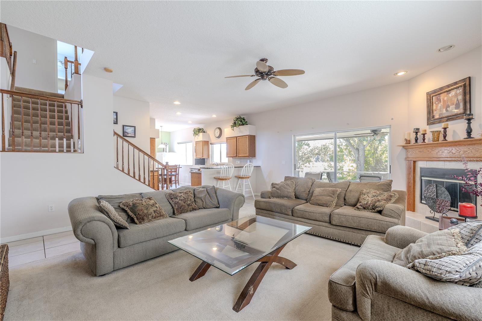 Open-concept main living area features a spacious family room with a cozy fireplace, soaring ceilings, and seamless flow to the kitchen and breakfast nook—perfect for entertaining.