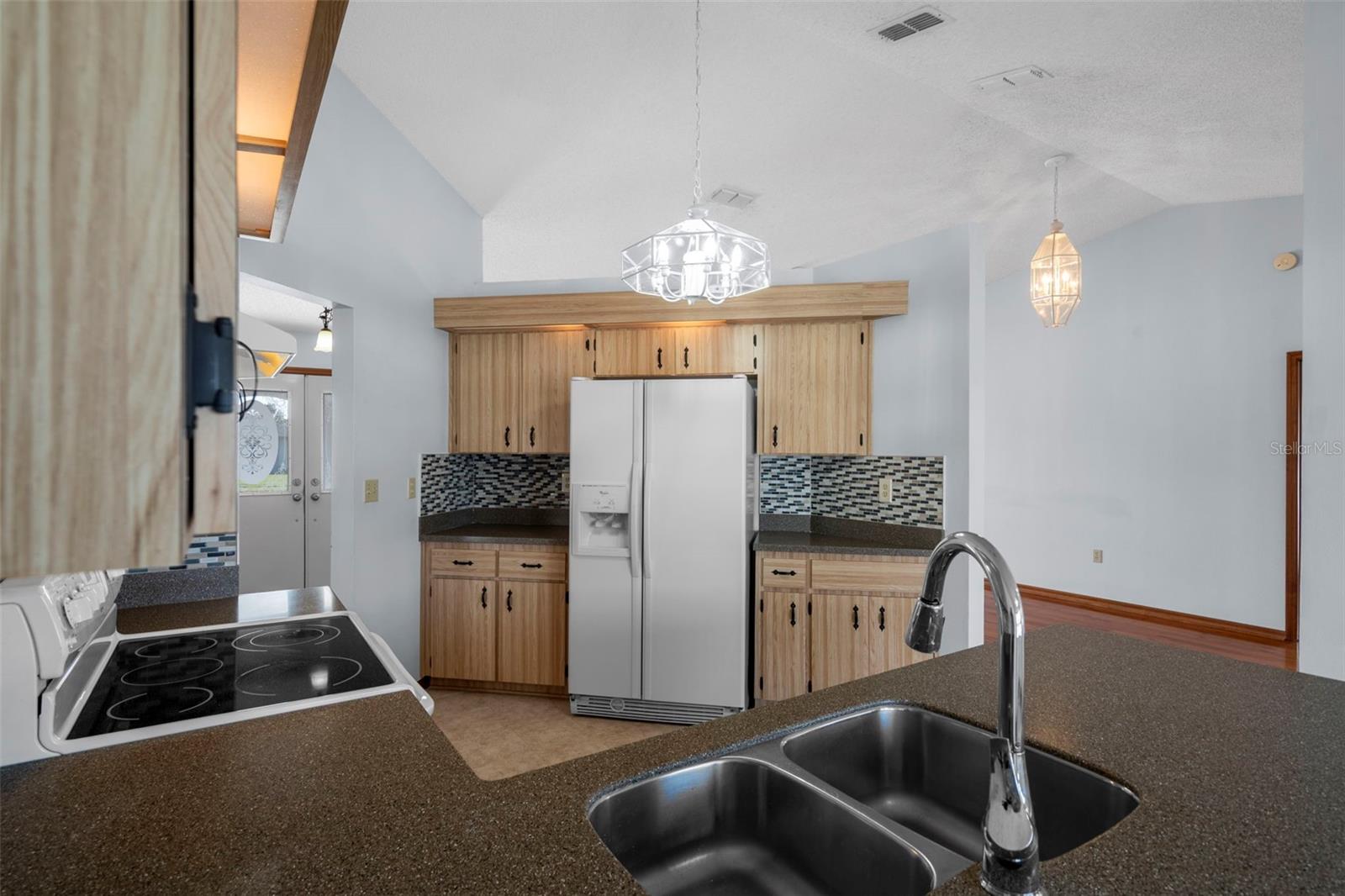 Fridge showing two entry points into kitchen