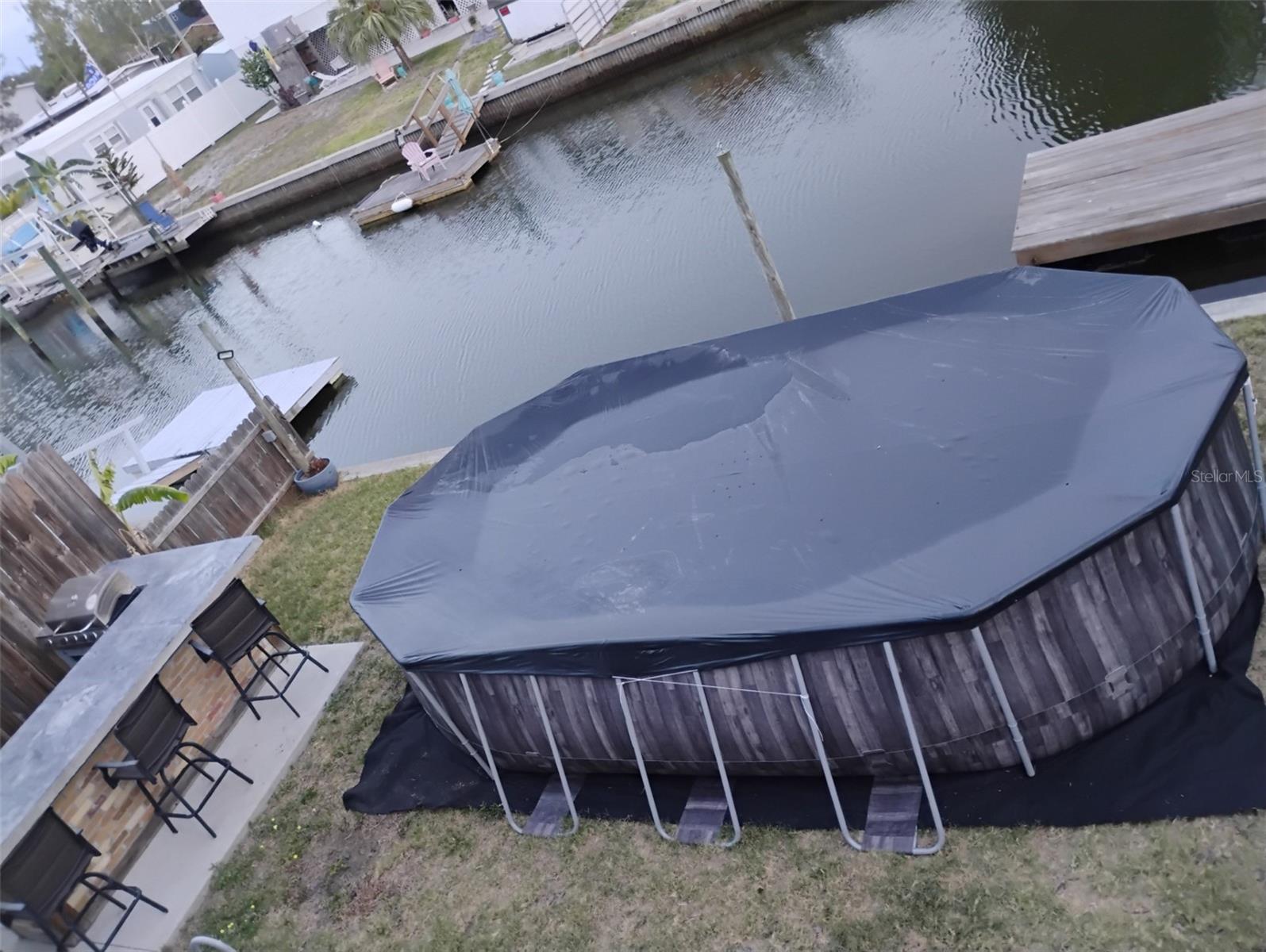 big above ground pool addedoutdoor kitchen with bar stools