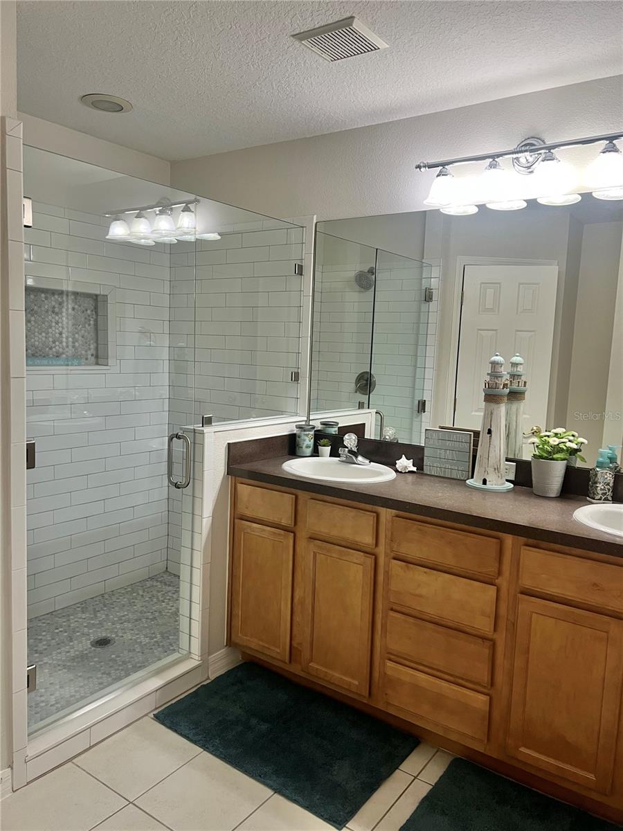 Solid wood vanity with 2 sets of cabinets and four drawers, Double sinks, Updated lighting, an Exhaust fan to keep humidity down, and a LARGE walk-in closet.