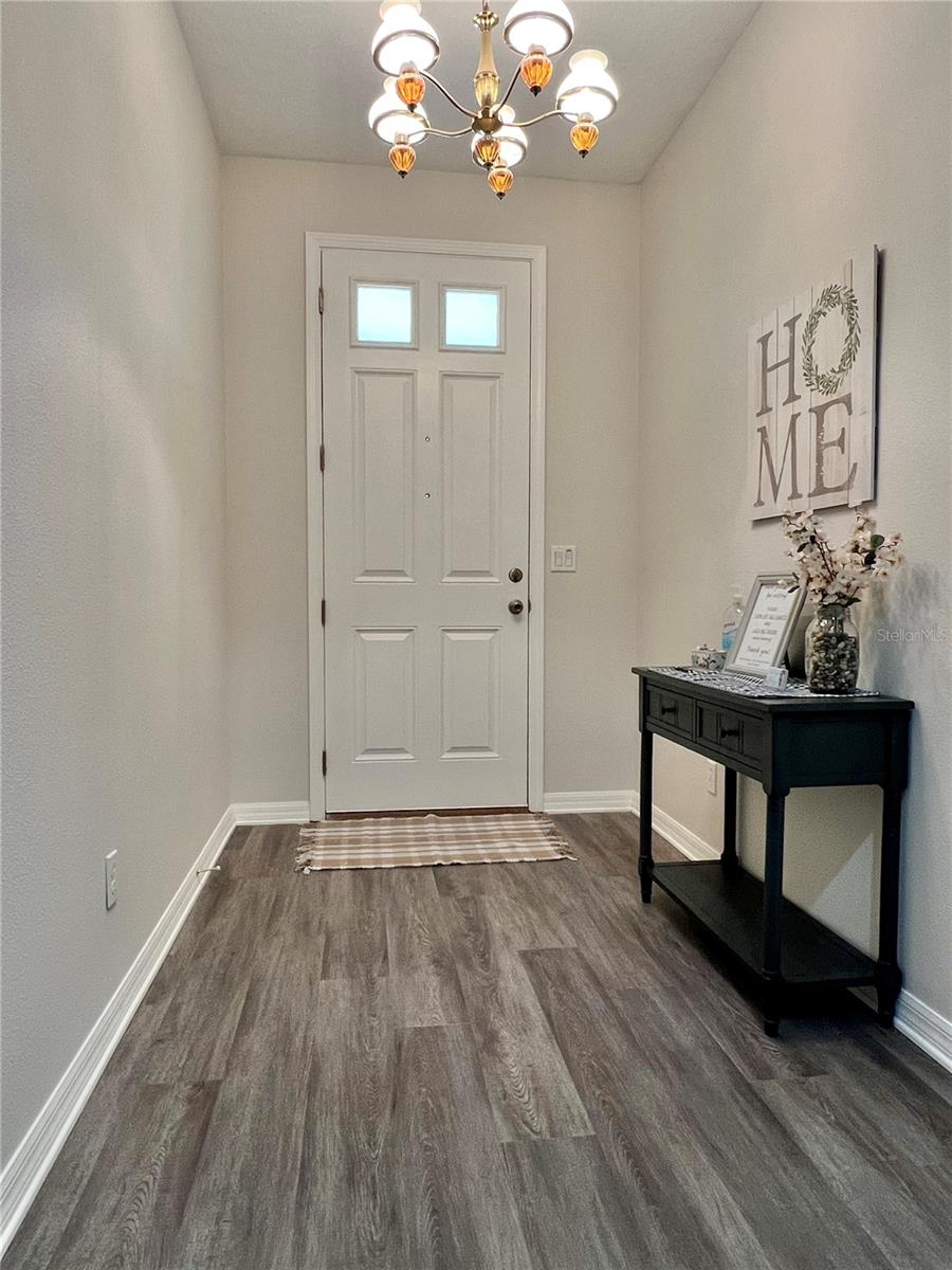 An EIGHT-FOOT entry door PLUS brand new luxury vinyl plank flooring throughout the entire first floor.