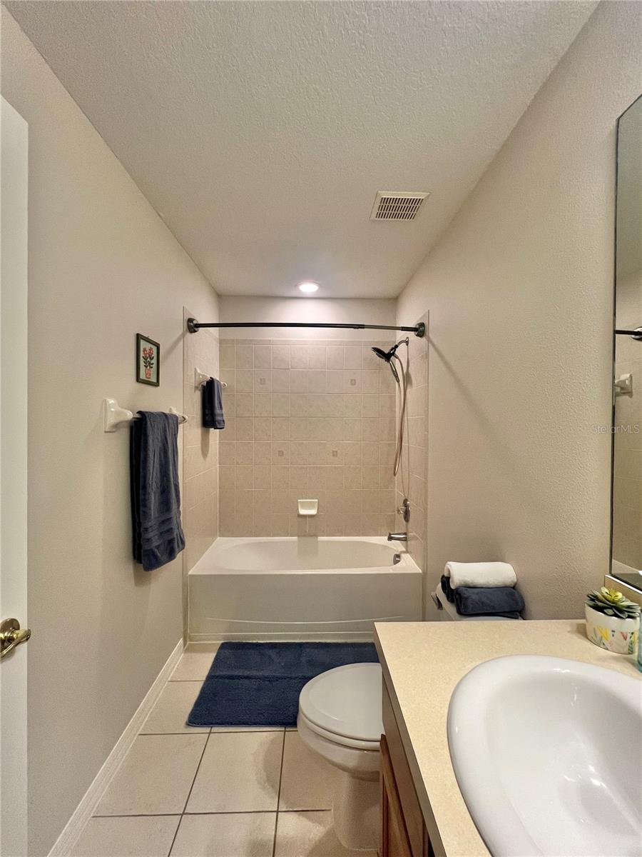 The second full bath features a double cabinet vanity, a tiled shower and oversized tub, and is very clean!