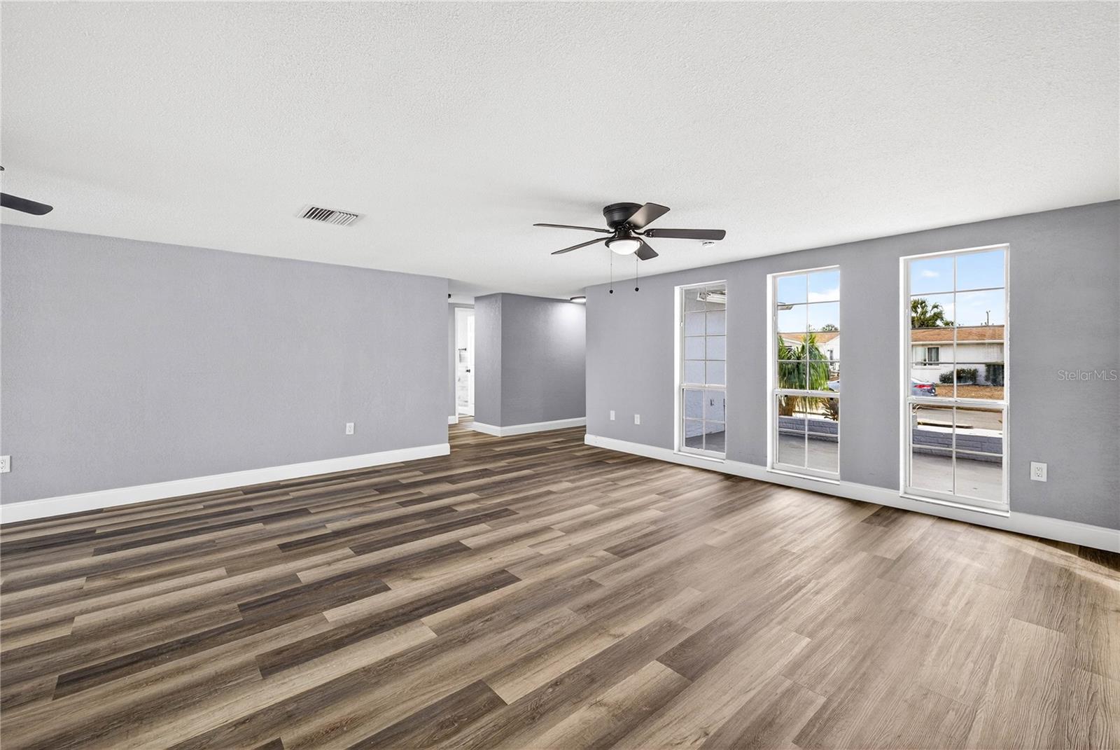 VIEW OF THE FRONT COURTYARD THROUGH LARGE FLOOR-TO-CEILING WINDOWS