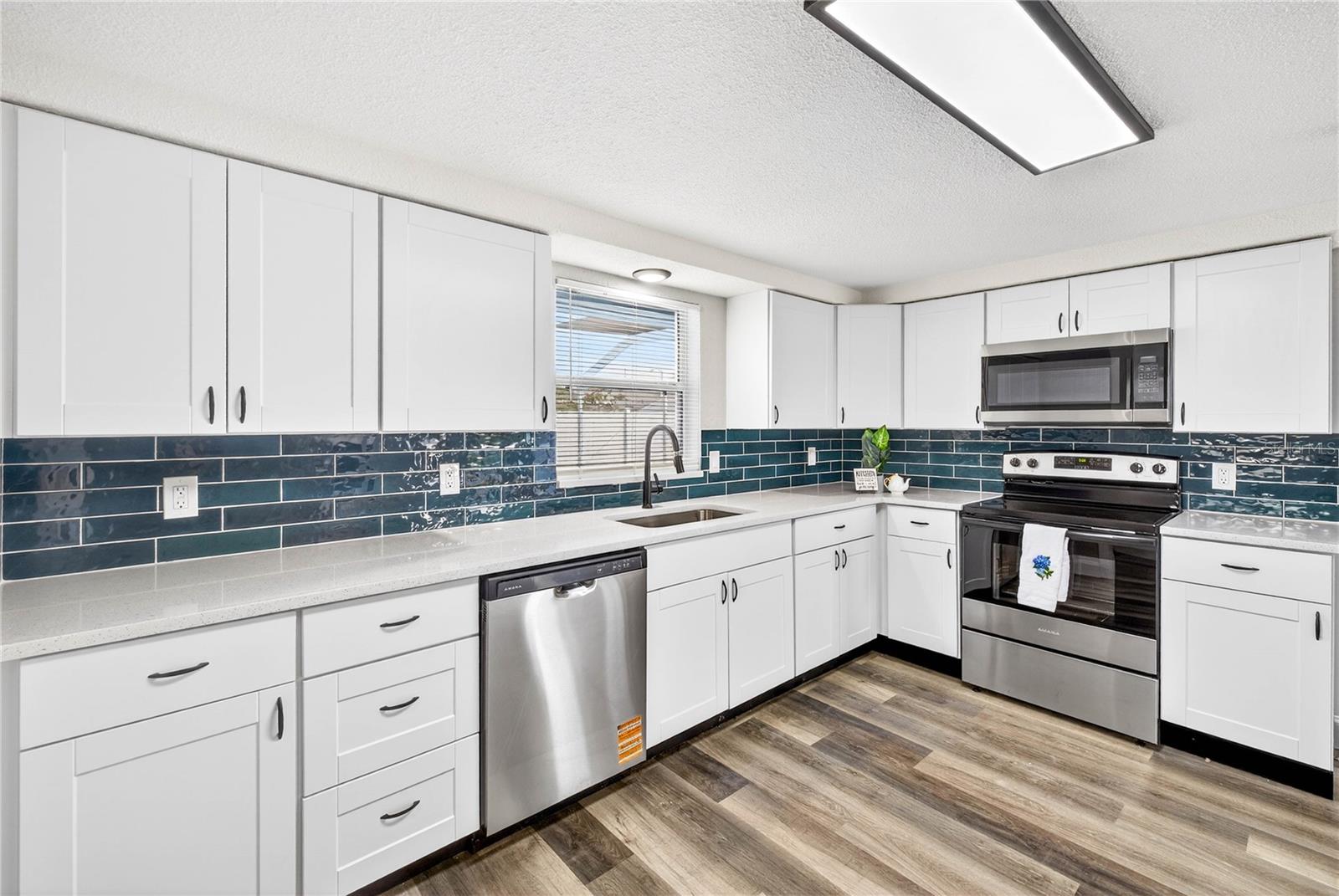 MODERN FIXTURES IN KITCHEN; WINDOW IS FACING SWIMMING POOL AREA