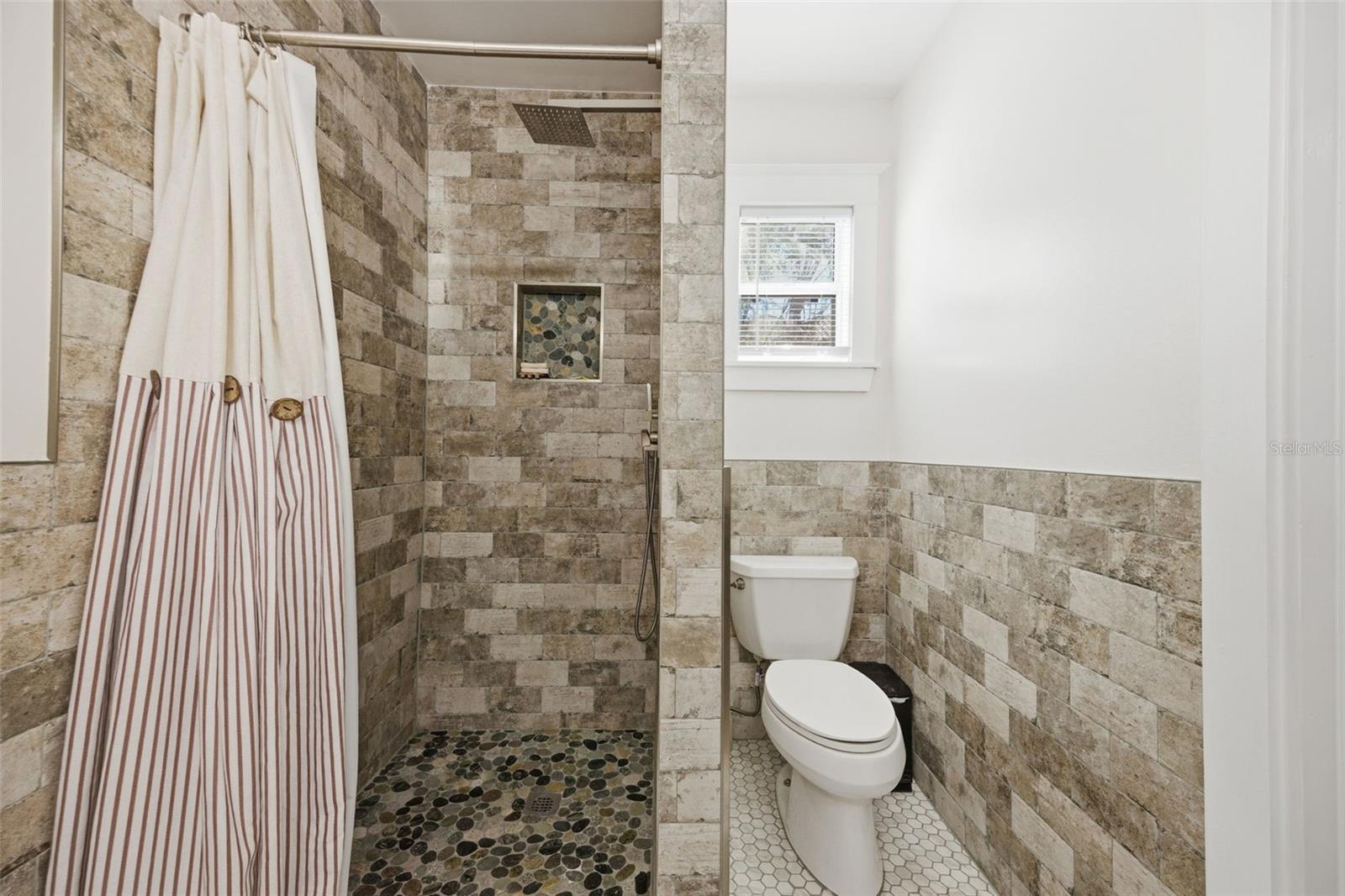 Primary shower with tucked away toilet