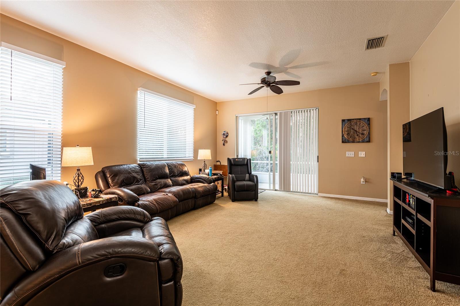Living room view with sliding doors to screened patio and backyard access