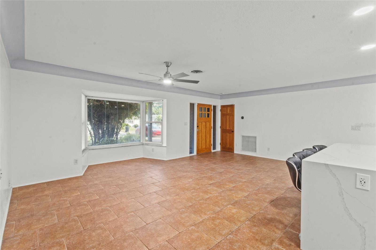 Expansive living space featuring durable tile flooring and neutral tones, ideal for flexible furniture layouts.