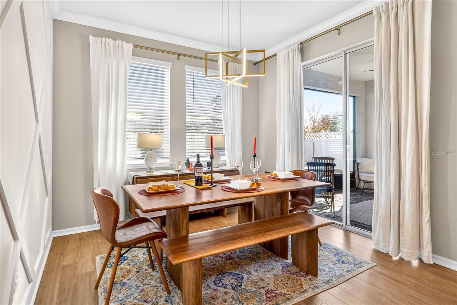 Dine elegantly inside or out.  Accent wall & light fixture frame the dining area.