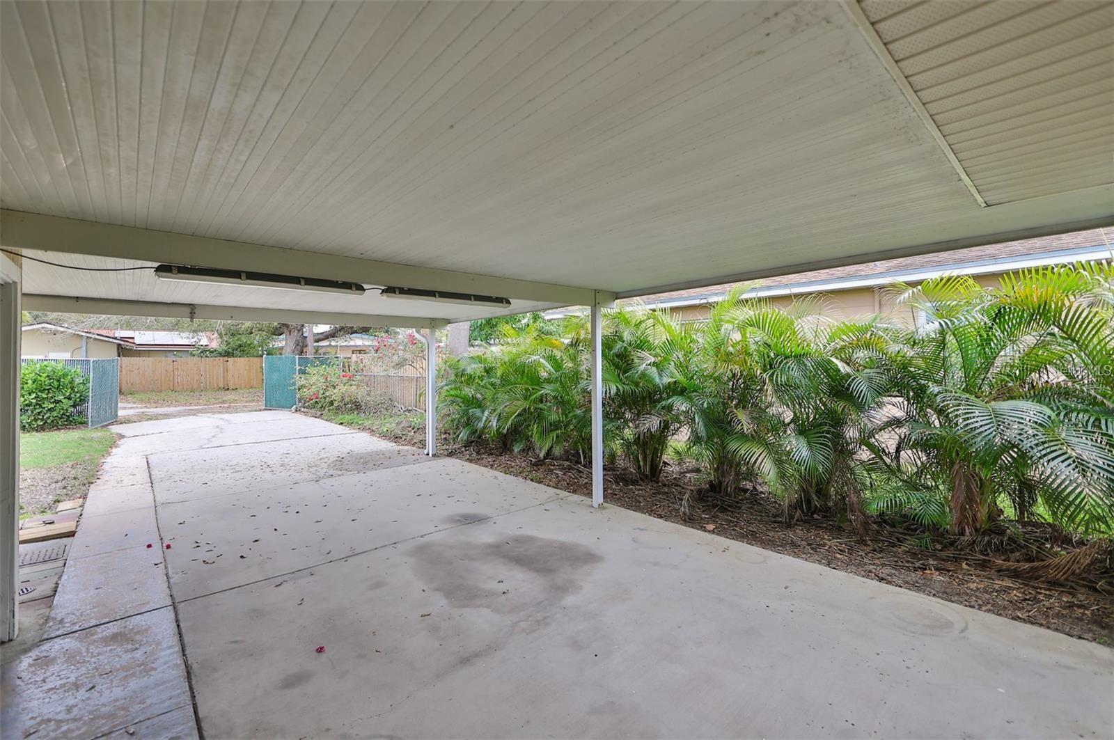 A lushly landscaped, fenced backyard pairs perfectly with the convenience of a covered carport and alley access.