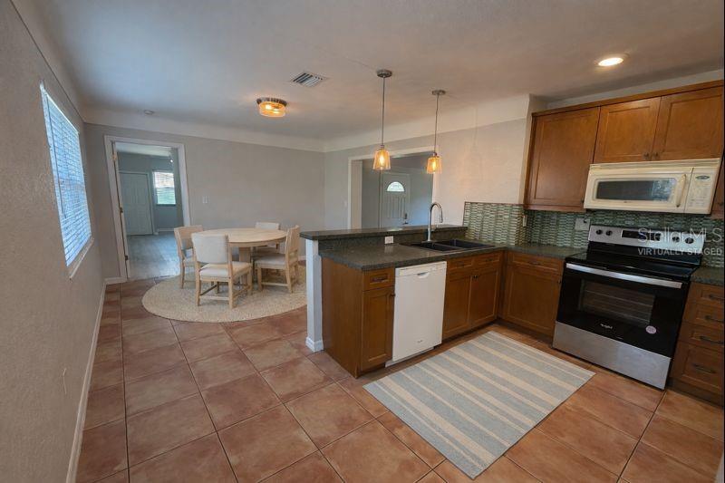 Open concept kitchen with generous counter space & seamless flow to the dining area. (Photo has been virtually staged to illustrate potential use of space).