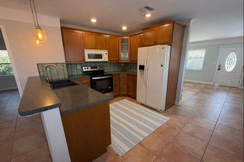 The kitchen features ample counter space & a snack bar, functioning as the home’s central hub with easy flow to the living & dining areas.