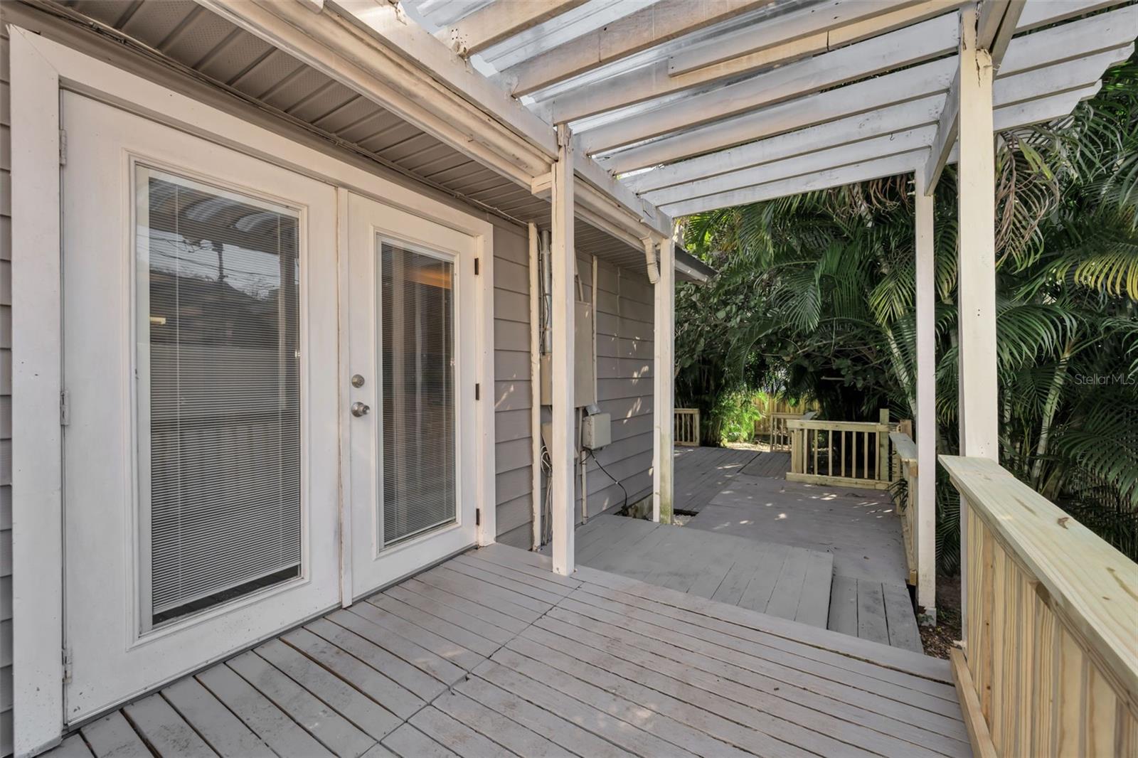 French doors lead to private, fenced back yard with deck