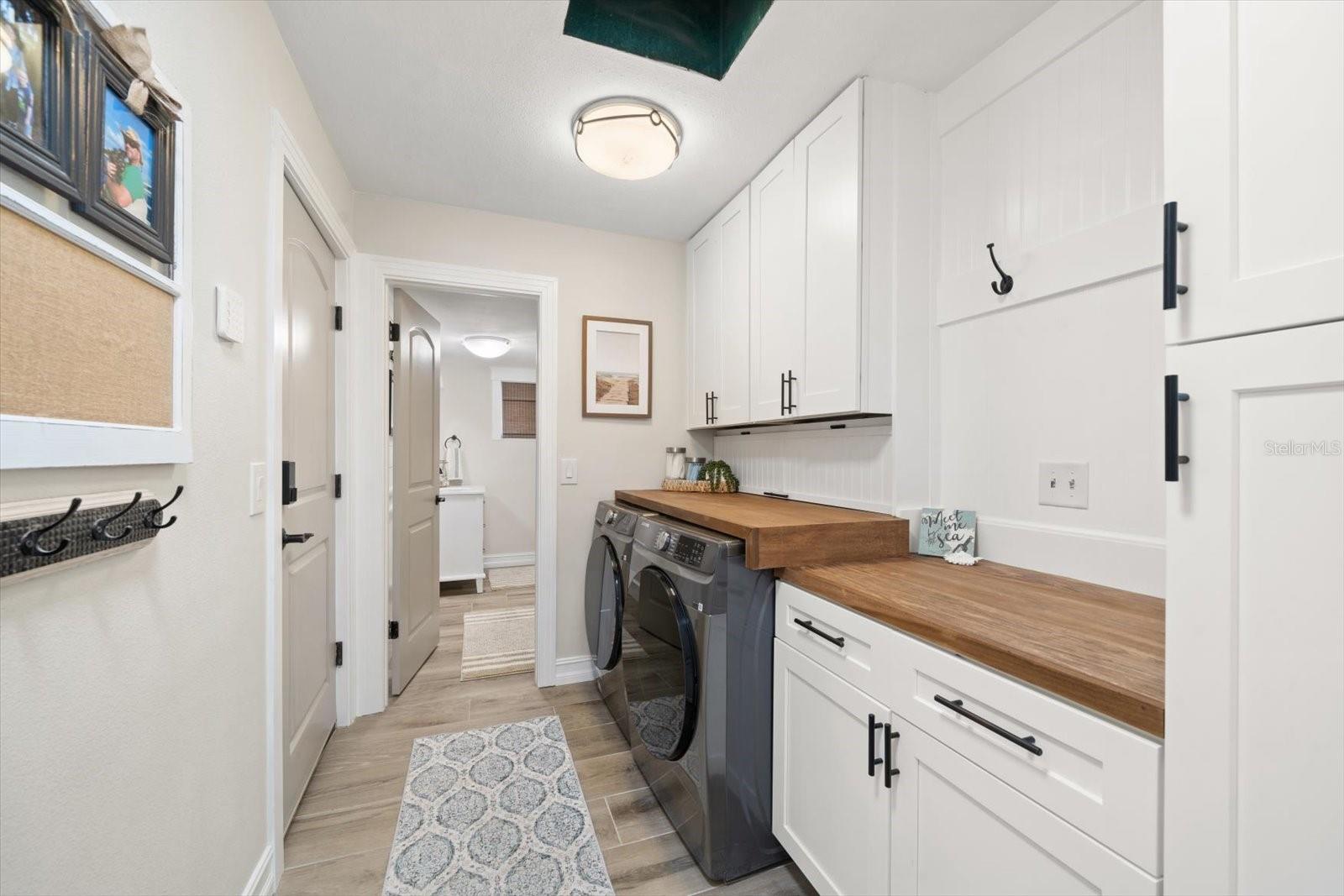 Laundry area with laundry chute, cabinets, and custom finishes!