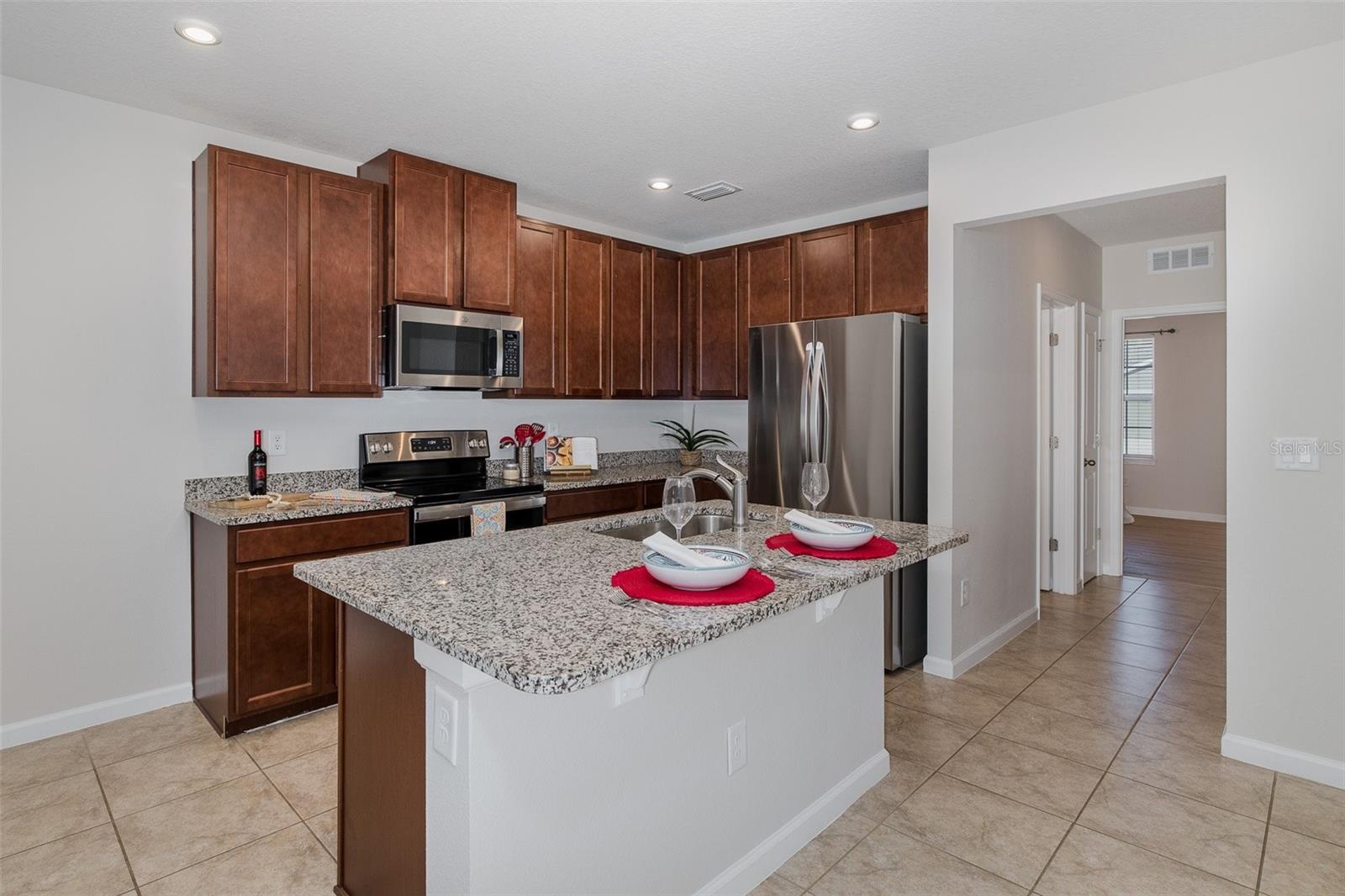 Kitchen looking toward bedroom 2, bath 2, laundry room and garage entrance