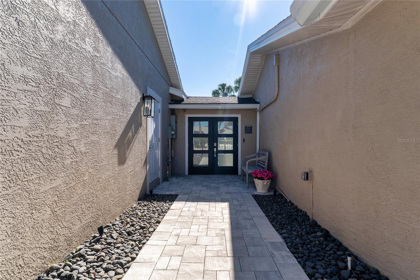 Double Glass-Paneled Door Between the Garages Leads to Entryway connected to Kitchen and Indoor Access to Private In-Law Suite