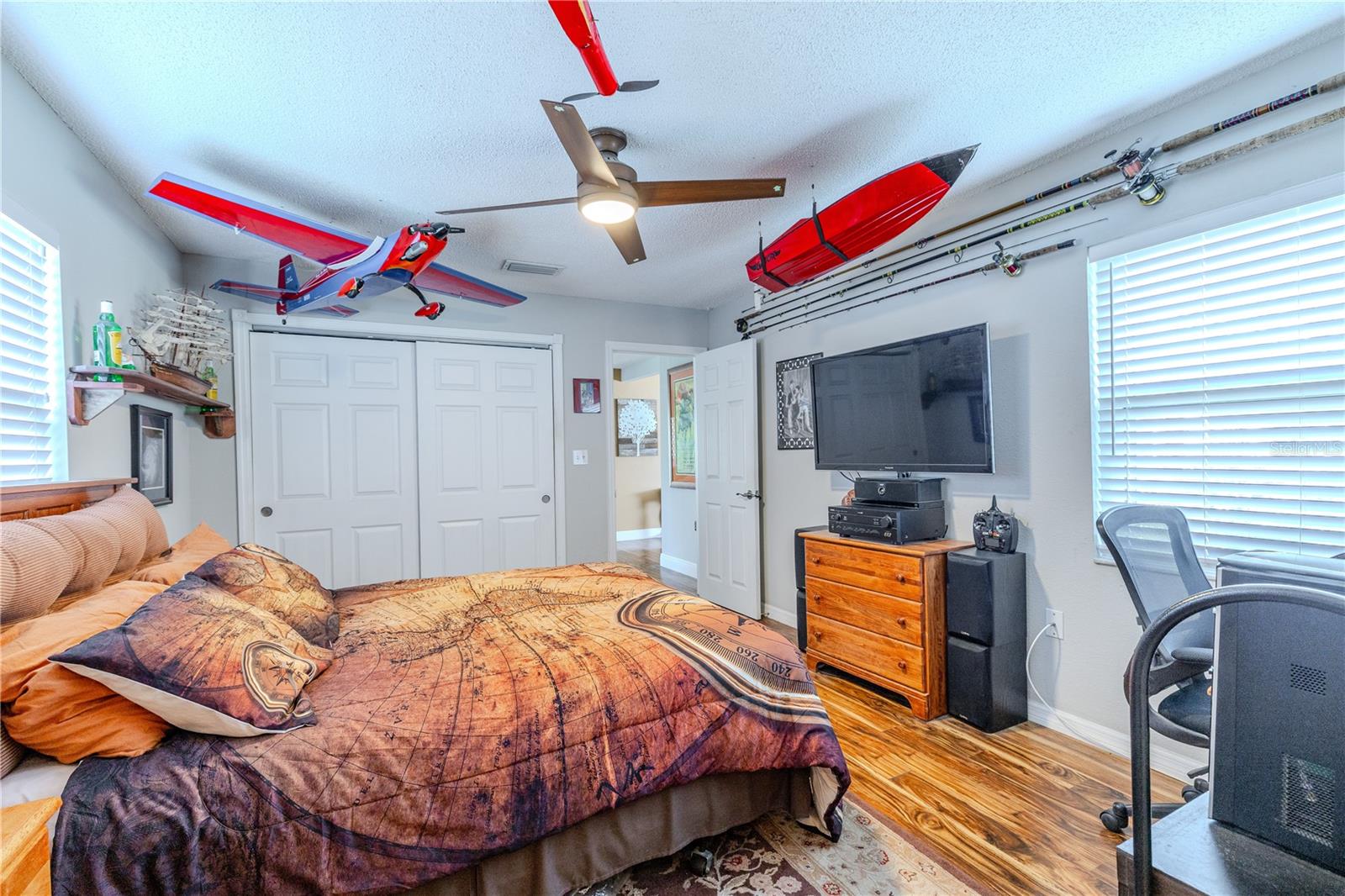Generously sized primary bedroom with laminate flooring, a ceiling fan for year-round comfort, and a layout that flows seamlessly into the en suite bath. Double sliding closet doors offer efficient storage while keeping the room open and uncluttered.