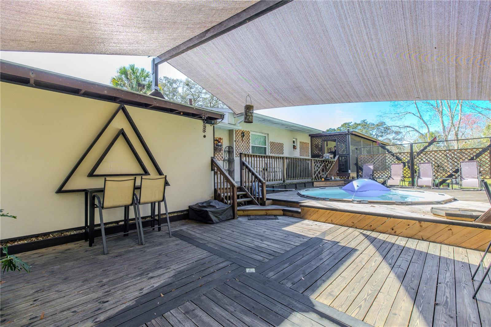 Elevated deck layout showcasing the relationship between the pool, shade sail, and surrounding deck levels for flexible outdoor use.