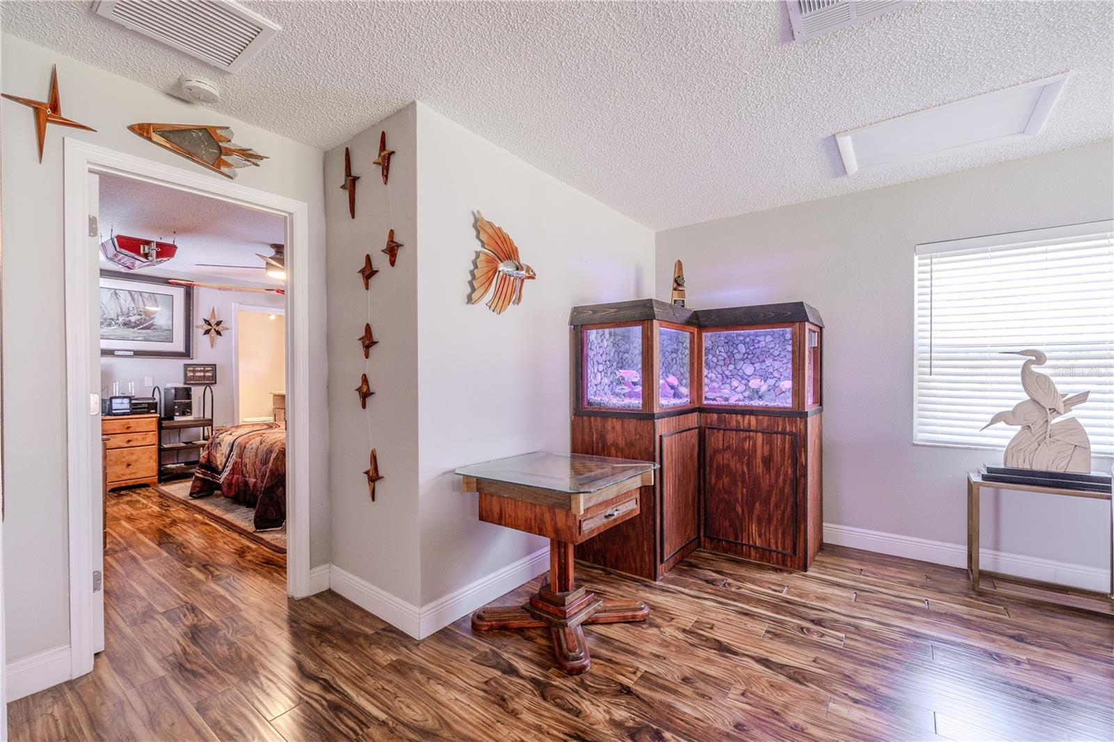 Inviting family room with durable laminate flooring and soft neutral walls, offering a flexible layout that connects easily to the nearby bedroom wing