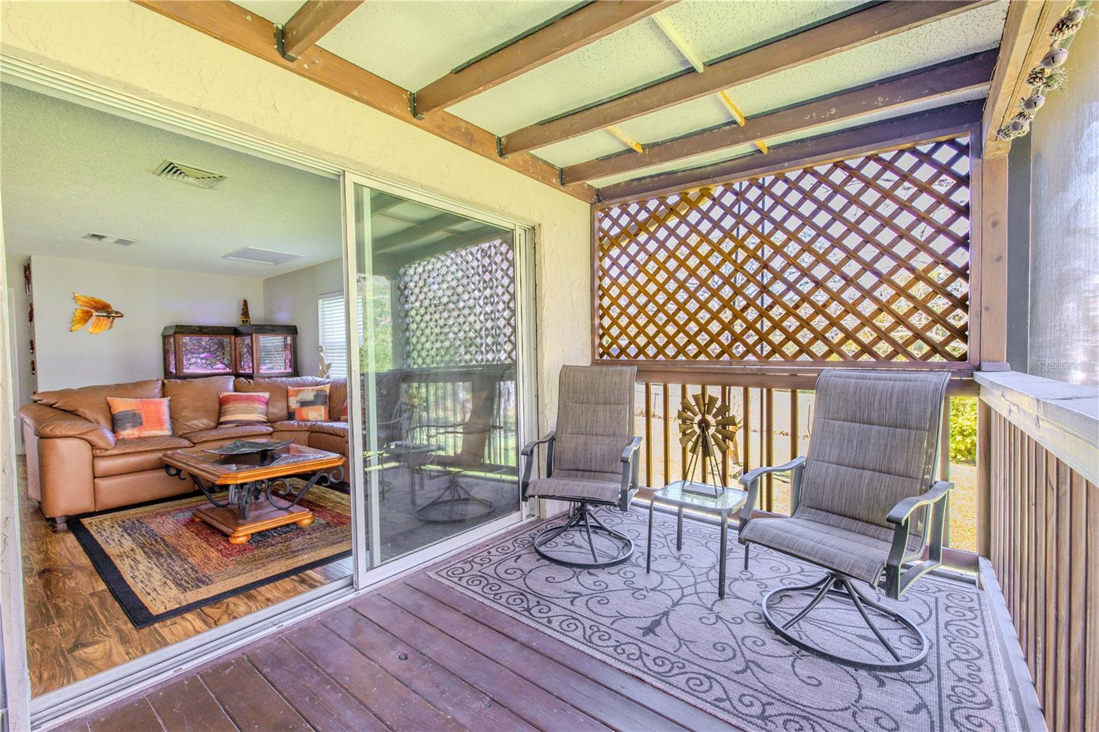 A cozy, covered deck offers a seamless indoor-outdoor connection, anchored by a sliding glass door that opens directly to the family room.